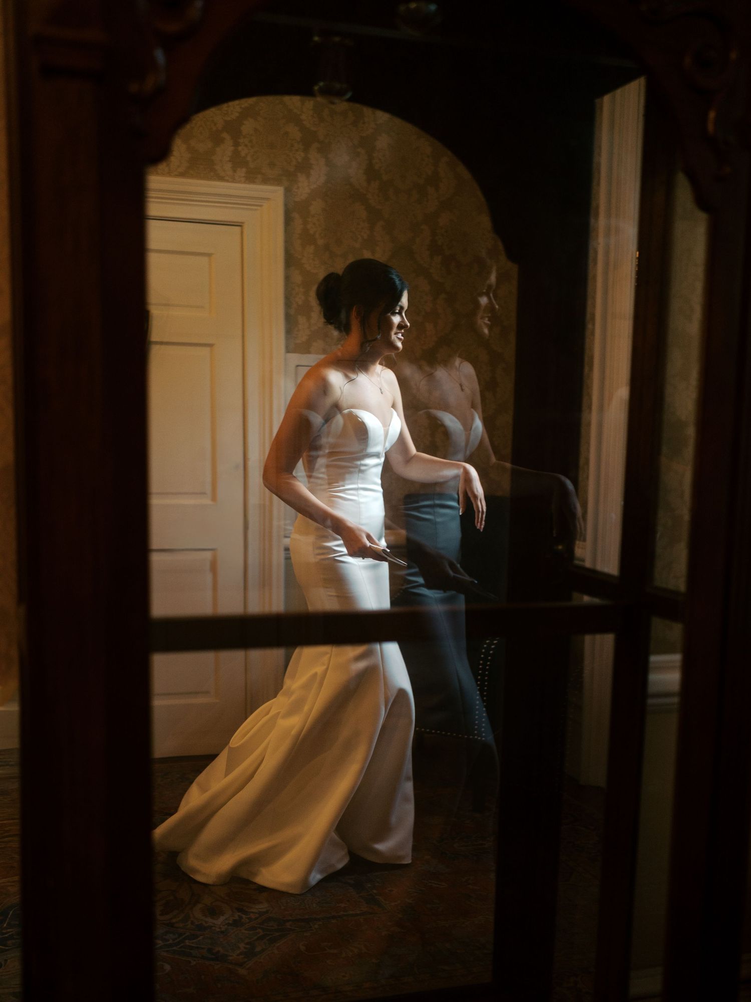 Dramatic silhouettes in a dimly lit hallway with white gowns.