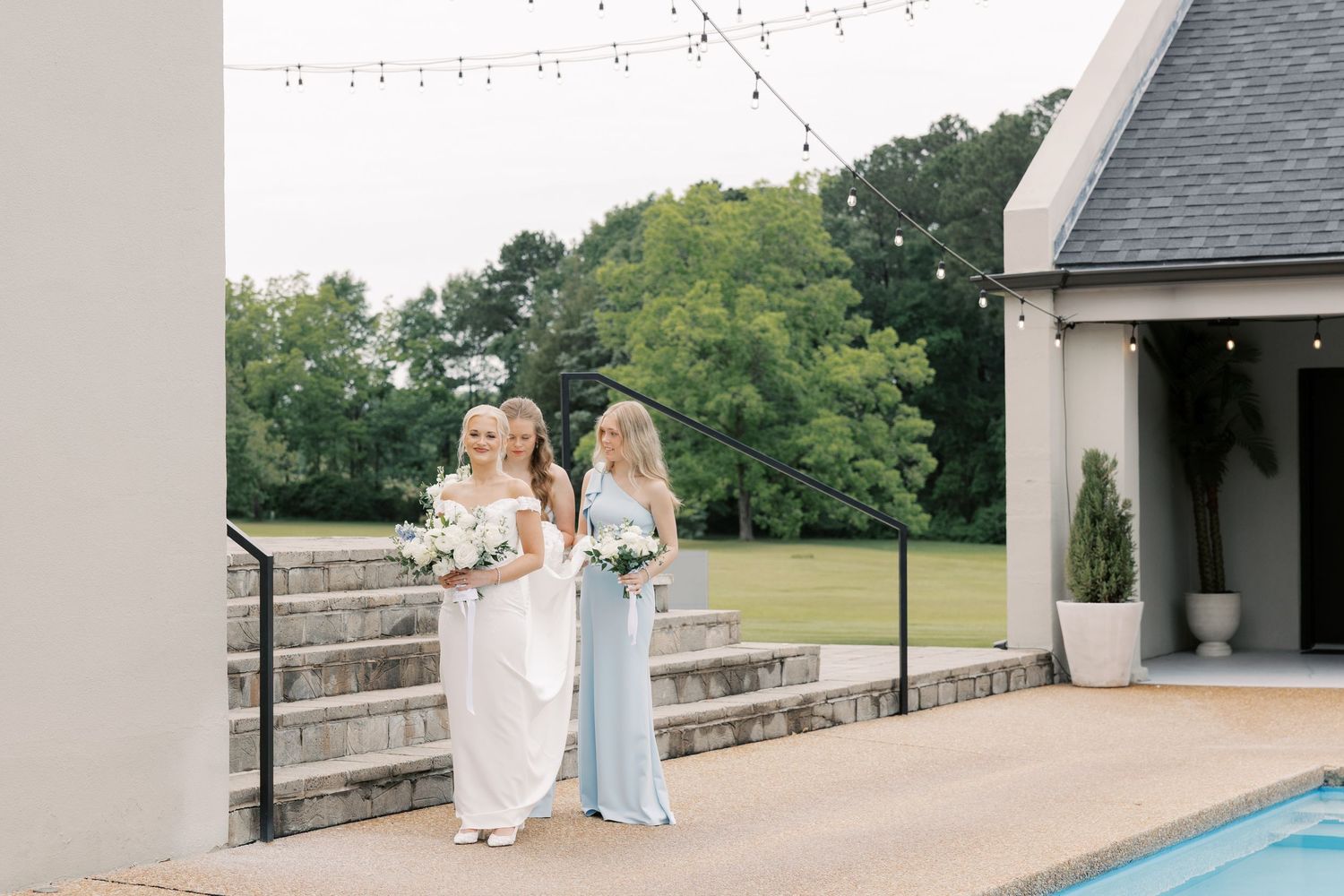 Minimalist wedding venue features string lights and modern white architectural details.