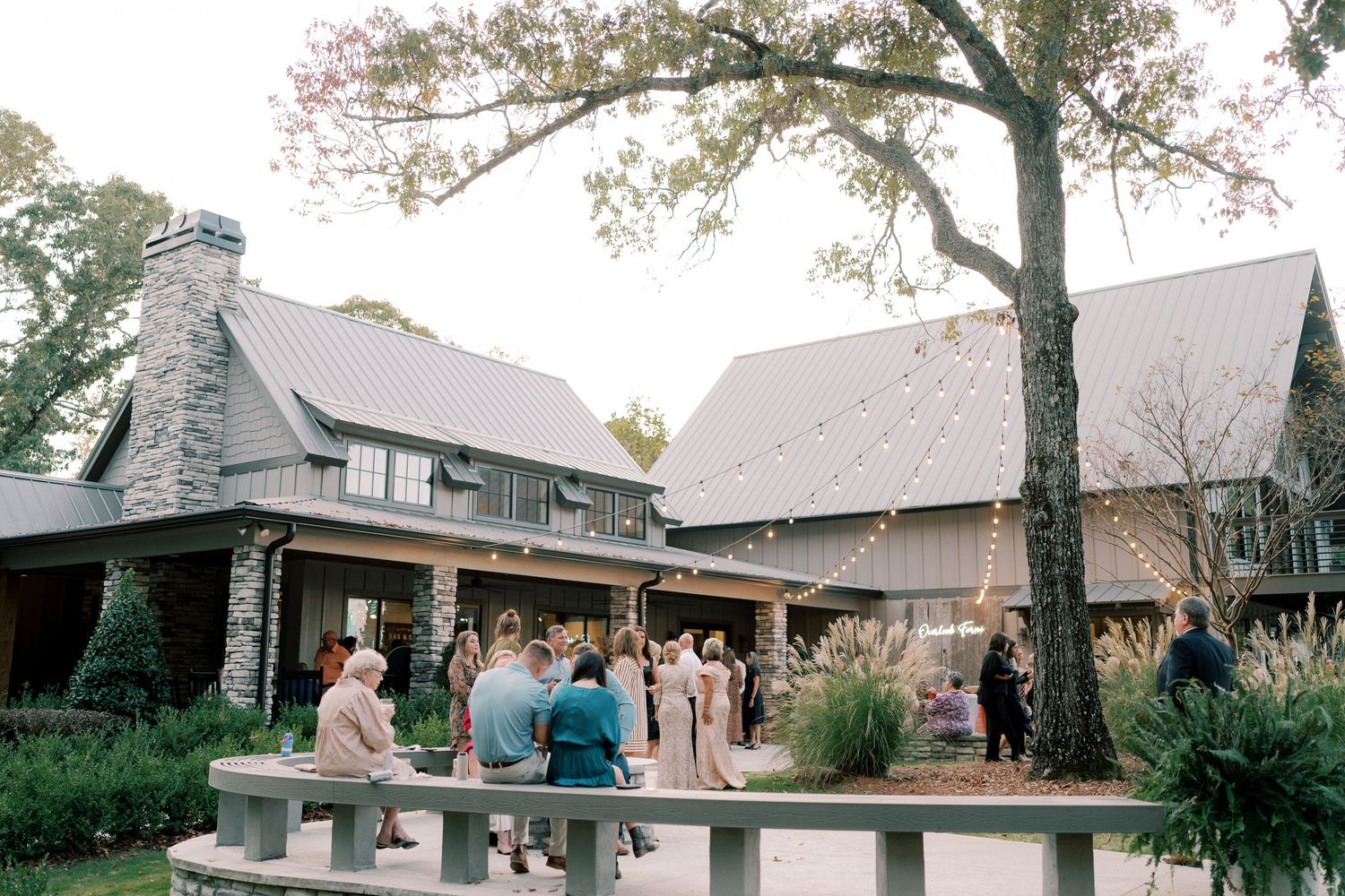 Rustic venue exterior with white buildings and trees during an autumn wedding celebration.