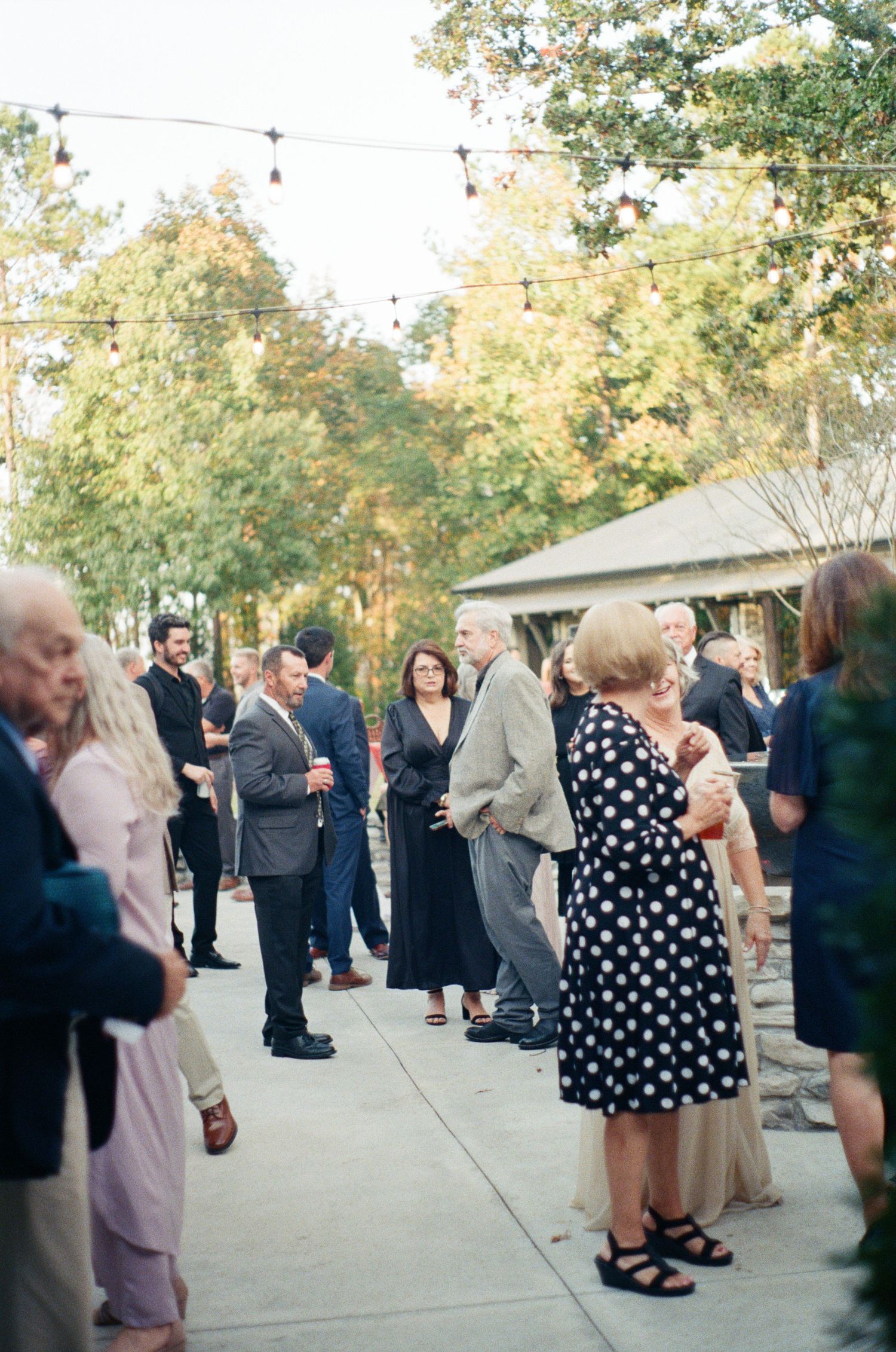 Wedding guests dancing on an outdoor patio during a reception celebration.