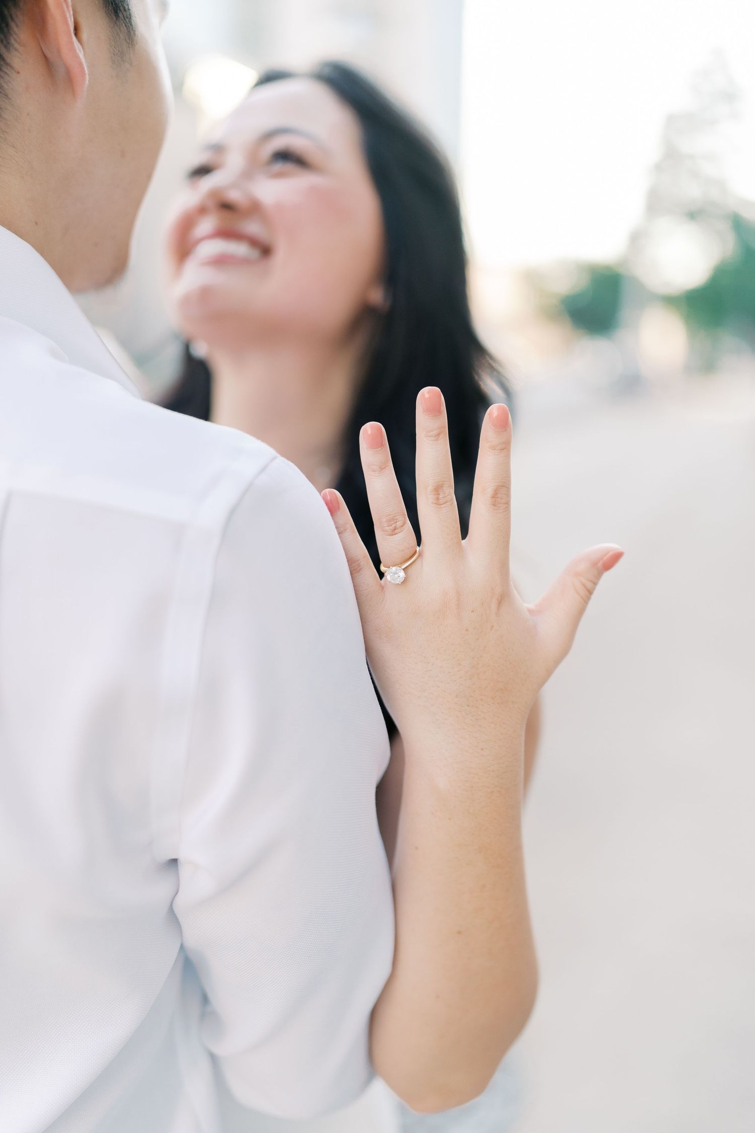 Hand with engagement ring shown during romantic outdoor photoshoot.