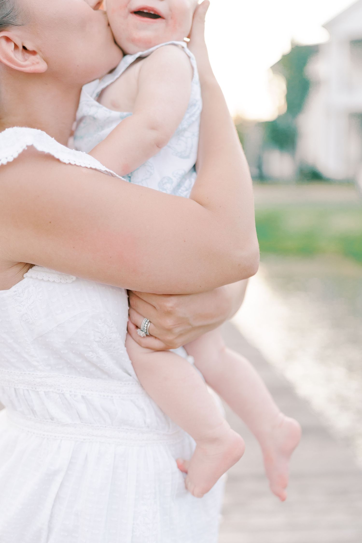 Close-up shots of tender moments between parent and baby in white summer outfits.