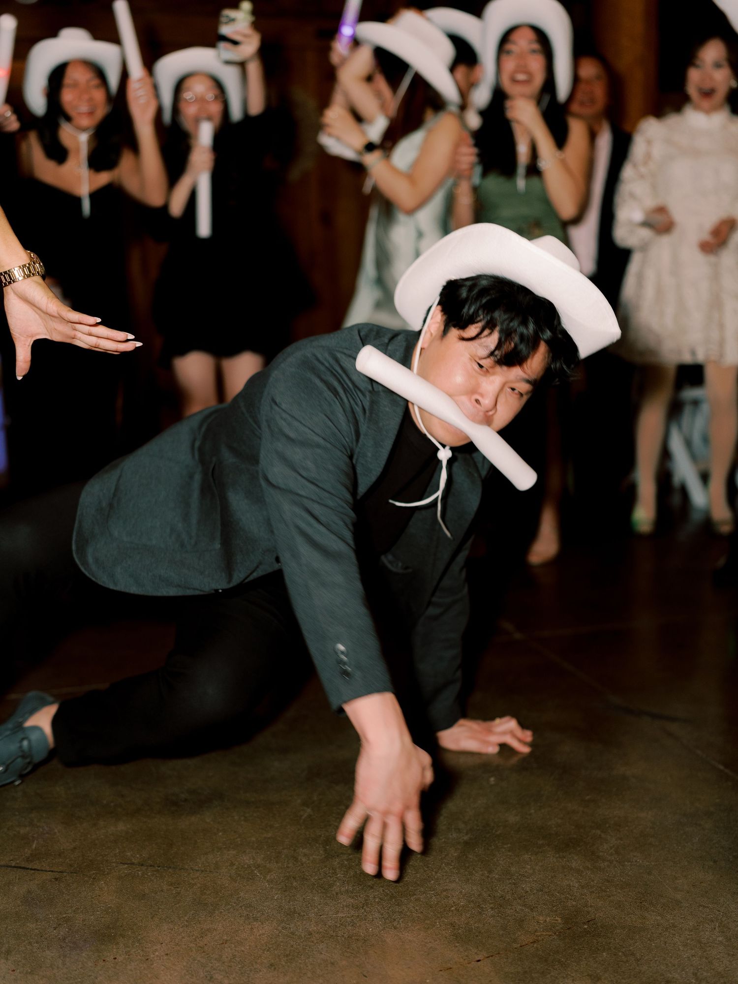 Guests performing synchronized dance moves on a dark dance floor at an event.