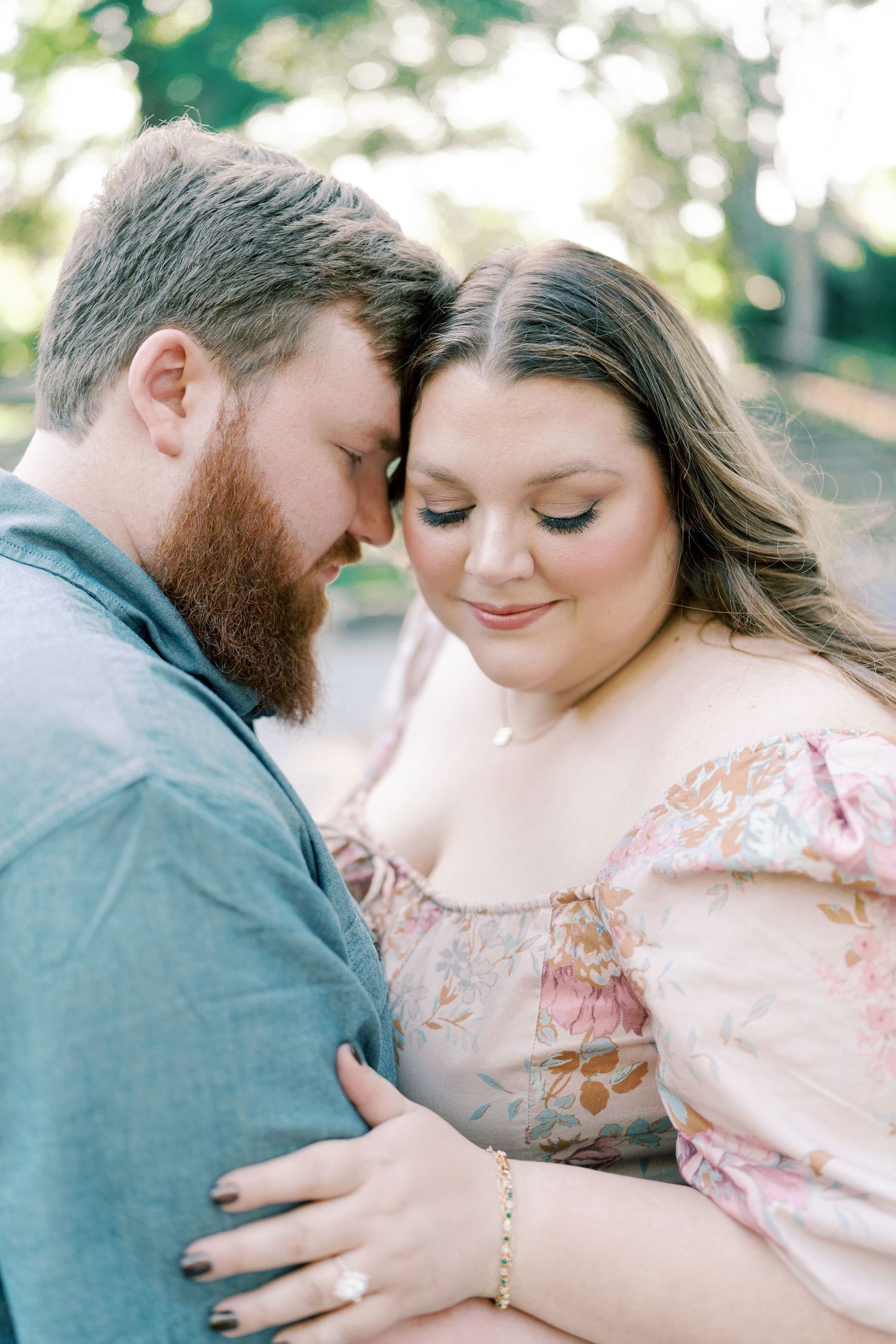 Tender moments captured between a couple in soft, dreamy garden lighting.