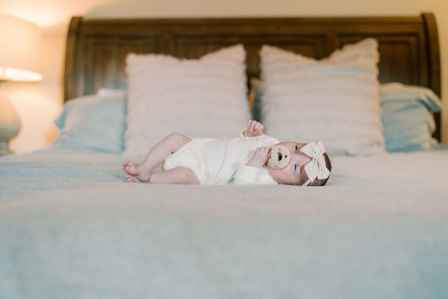 Soft focus image of sleeping infant on white bedding.