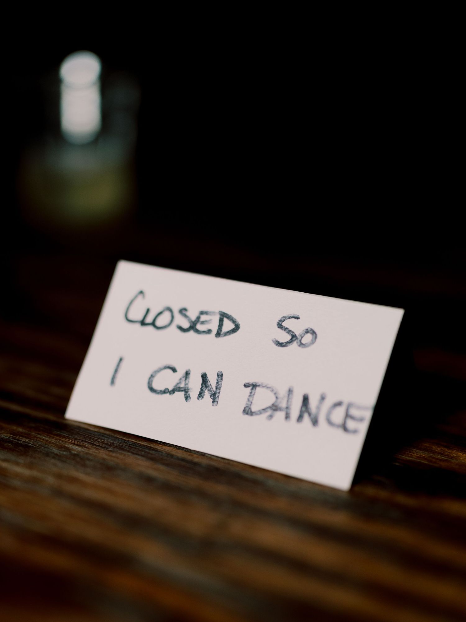 Close-up of a handwritten sign on a wooden surface.