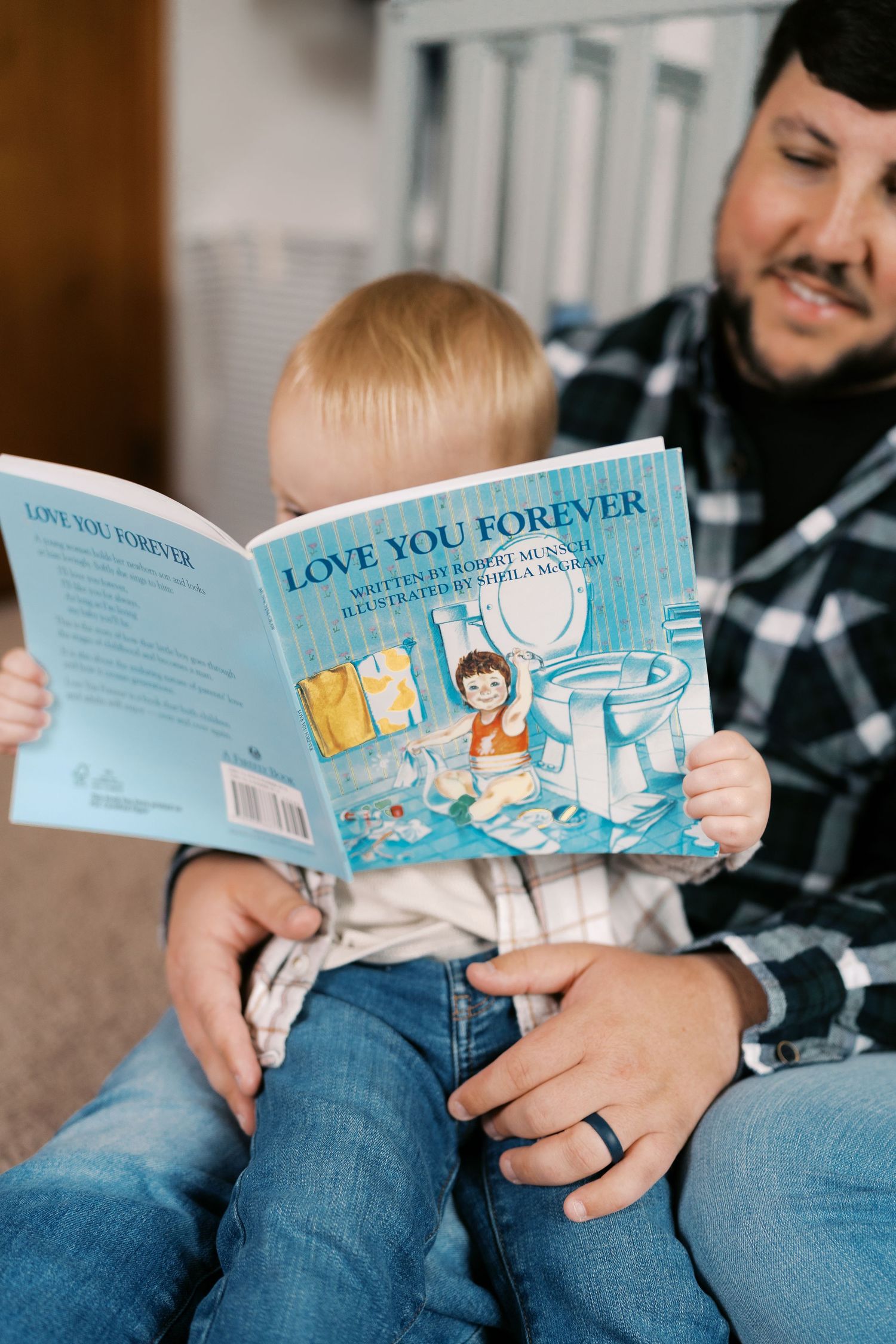 Reading 'Love You Forever' children's book together in nursery setting.
