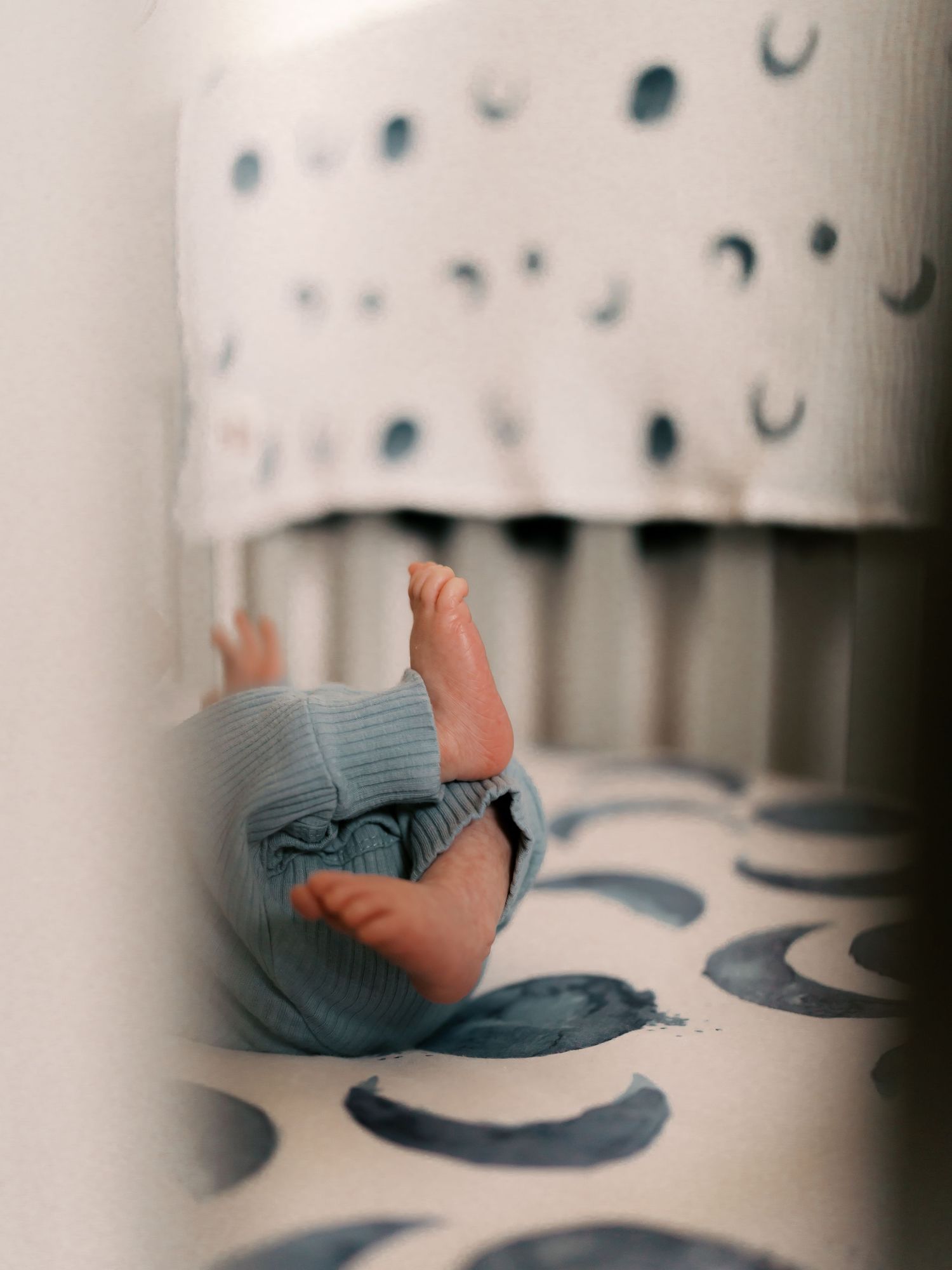 Artistic close-up of small feet against patterned nursery decor.