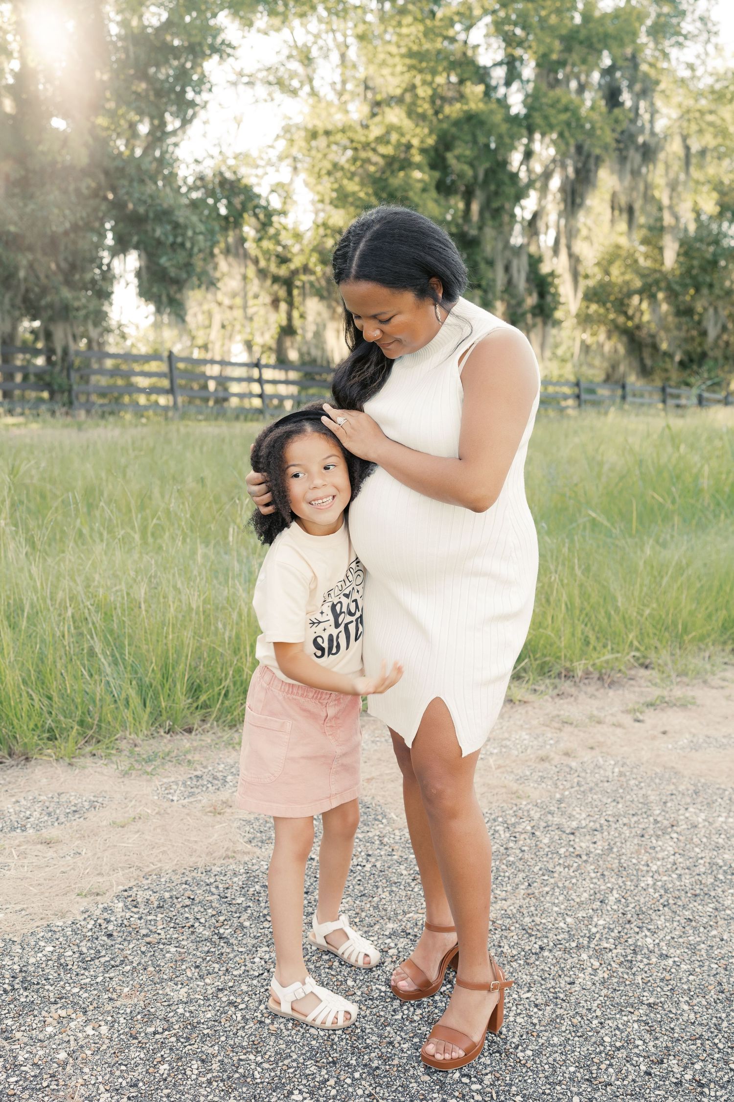 A joyful family moment captured during a pregnancy announcement photoshoot outdoors.