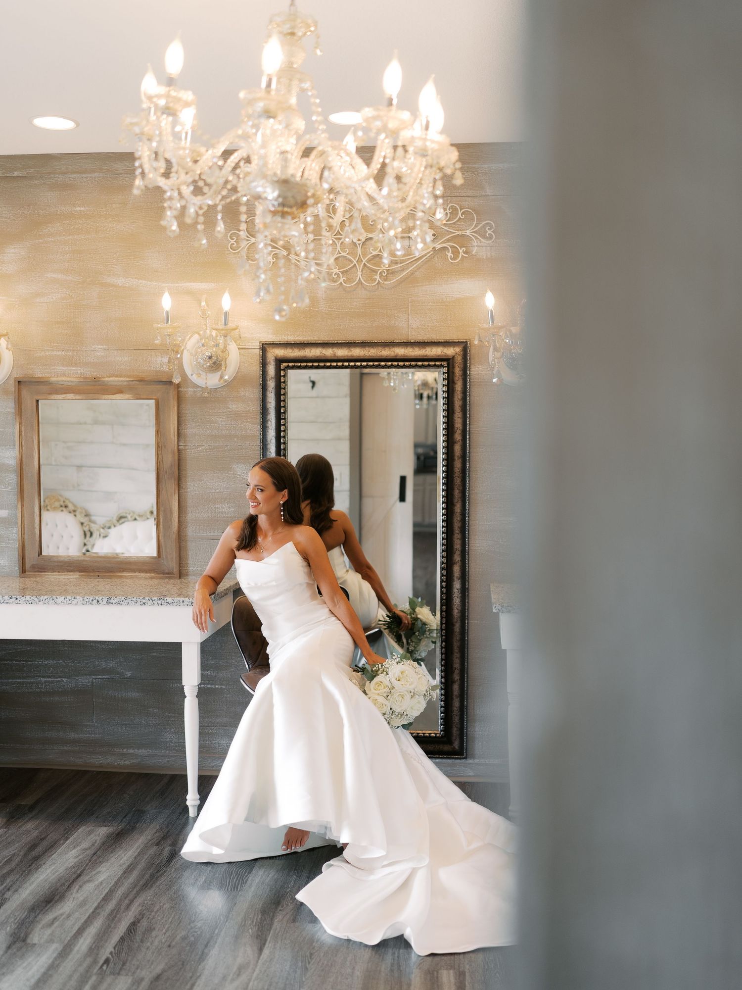 Elegant room with crystal chandelier and mirrors featuring flowing white dress movements.