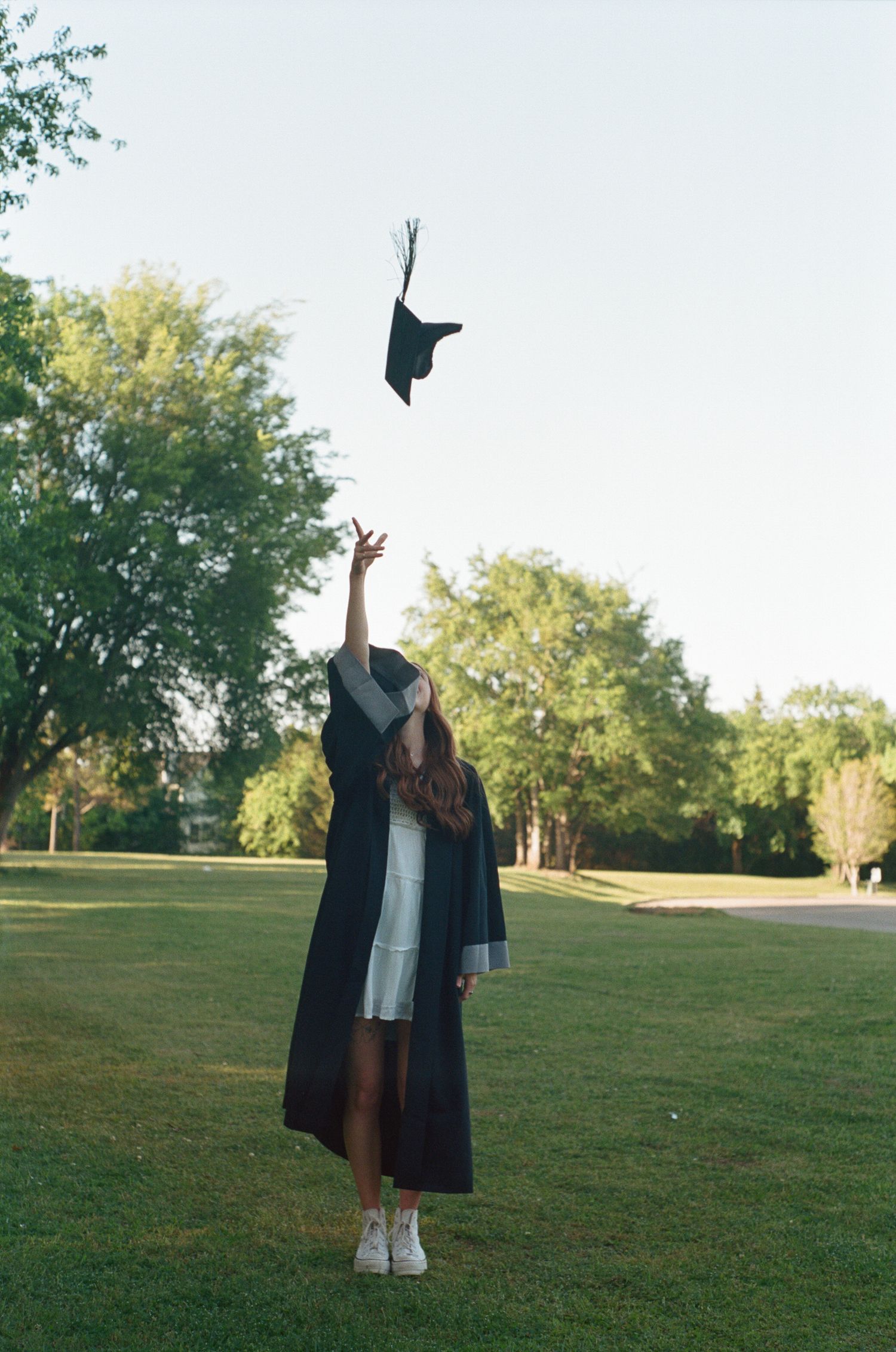 Graduation celebration photos showing cap toss and poses on grassy field at sunset.