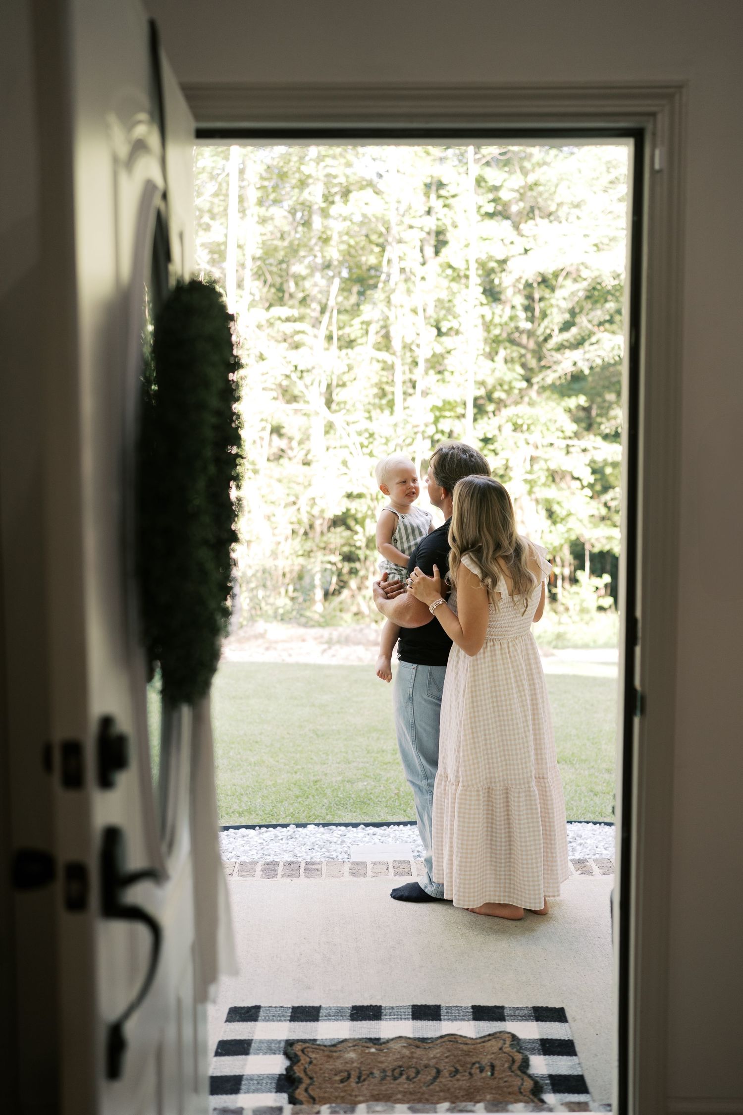 Two people look out through an open doorway with black and white checkered floor.