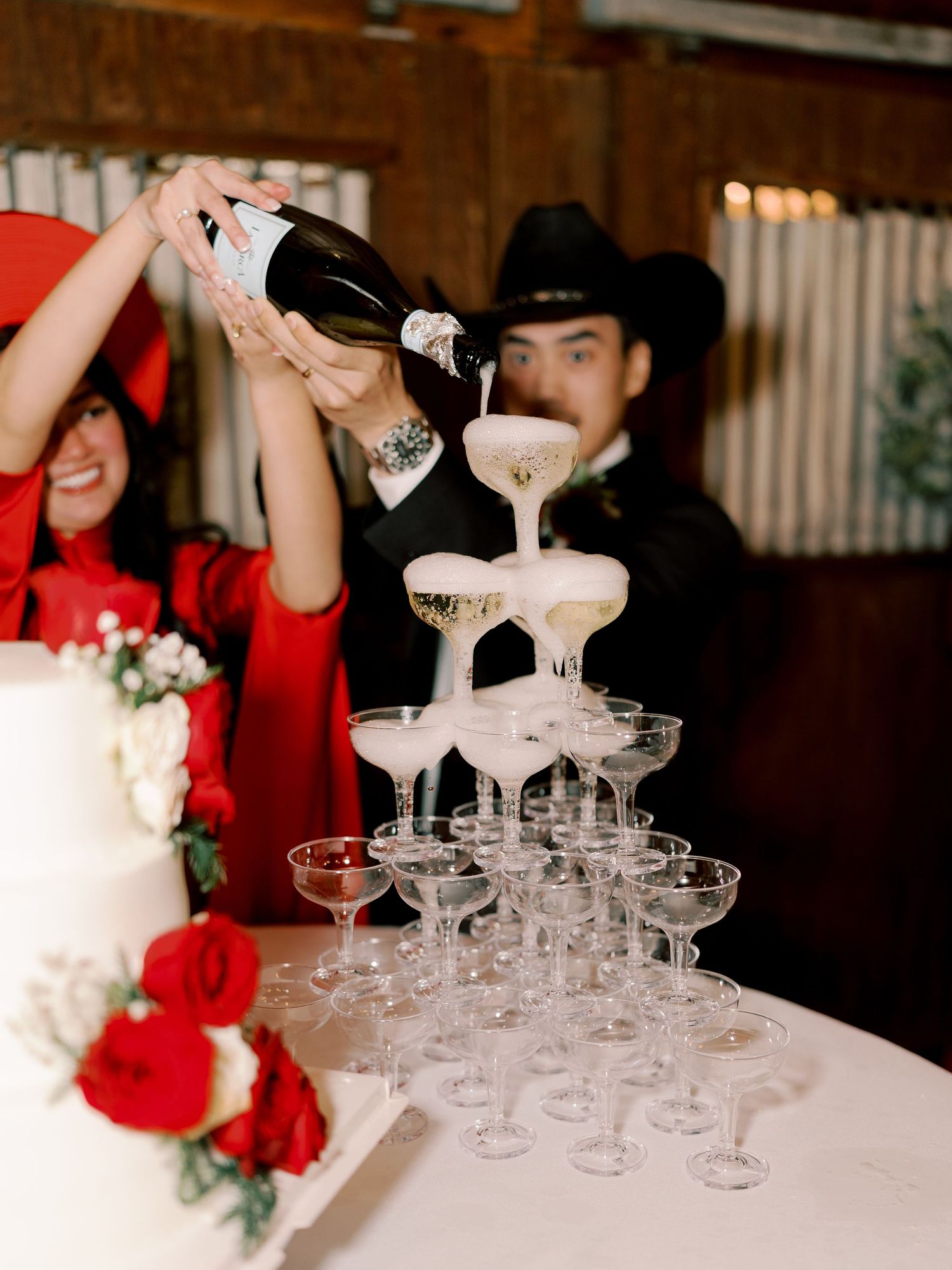 A champagne tower display with crystal coupe glasses at a wedding reception.