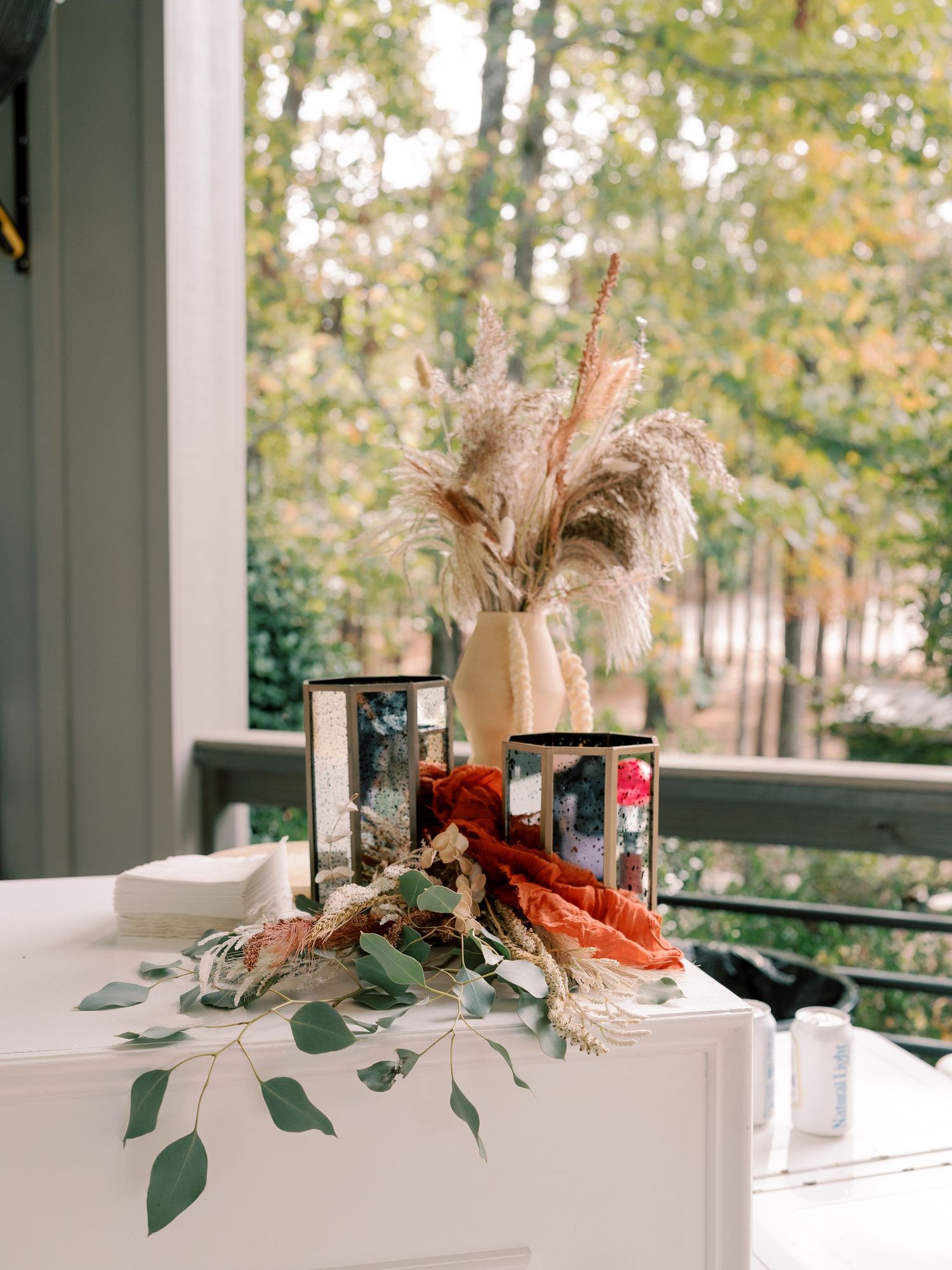 Wedding reception table decorated with dried pampas grass and eucalyptus centerpieces.