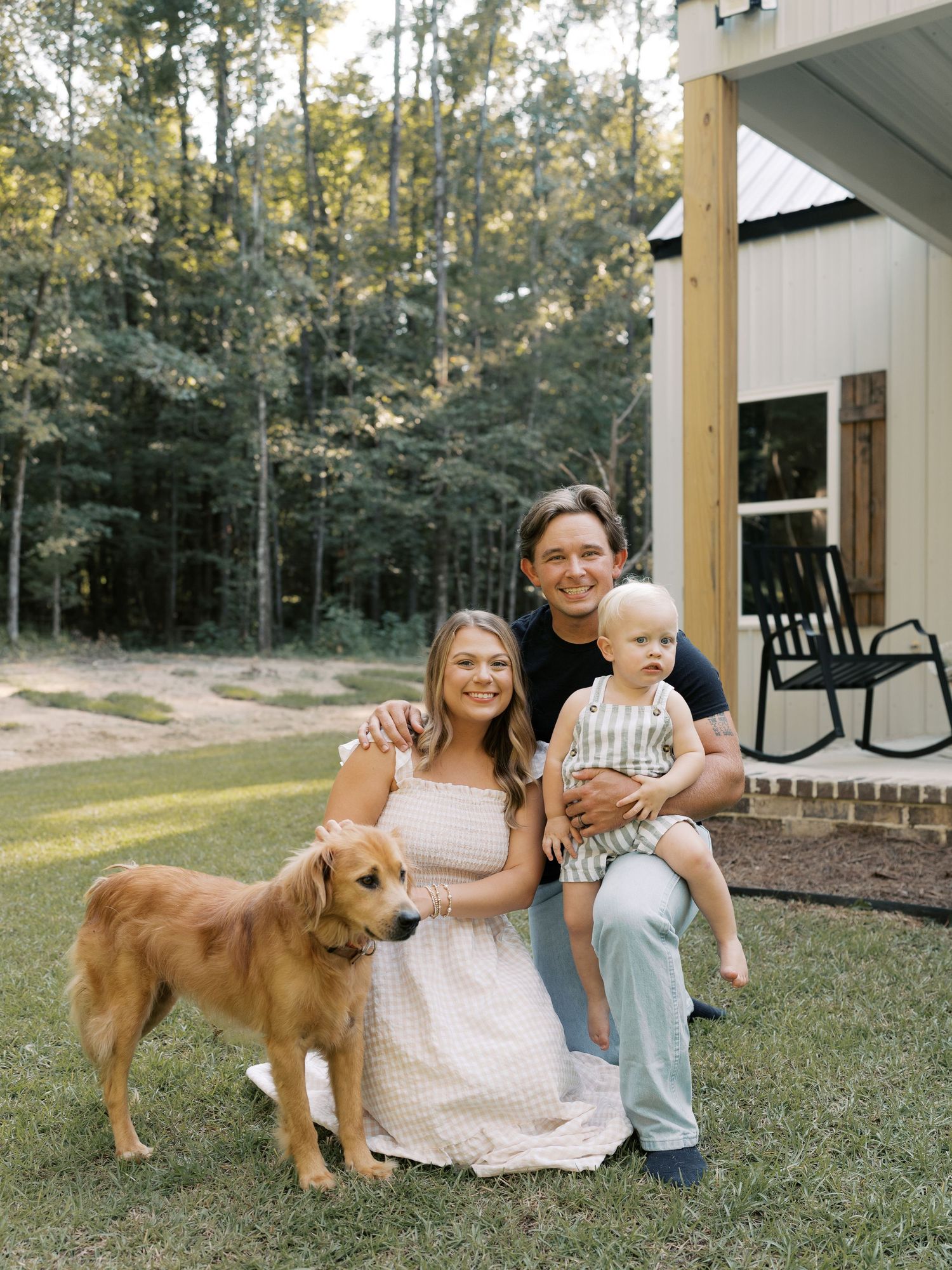 Family and their golden retriever dog relax together on their front porch.