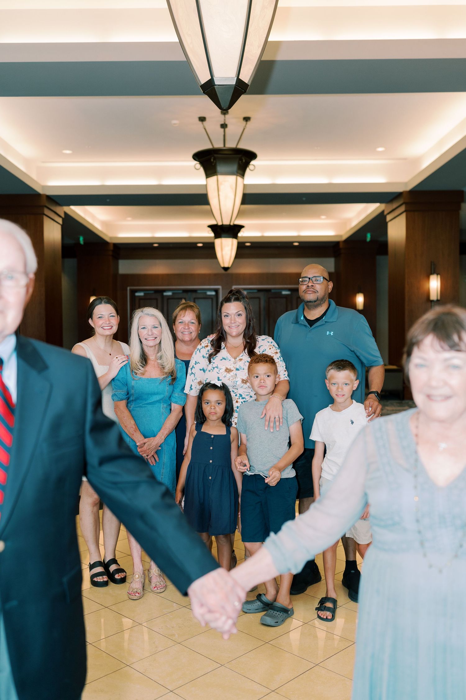 Extended family gathering in hotel lobby with coordinated blue and white outfits.