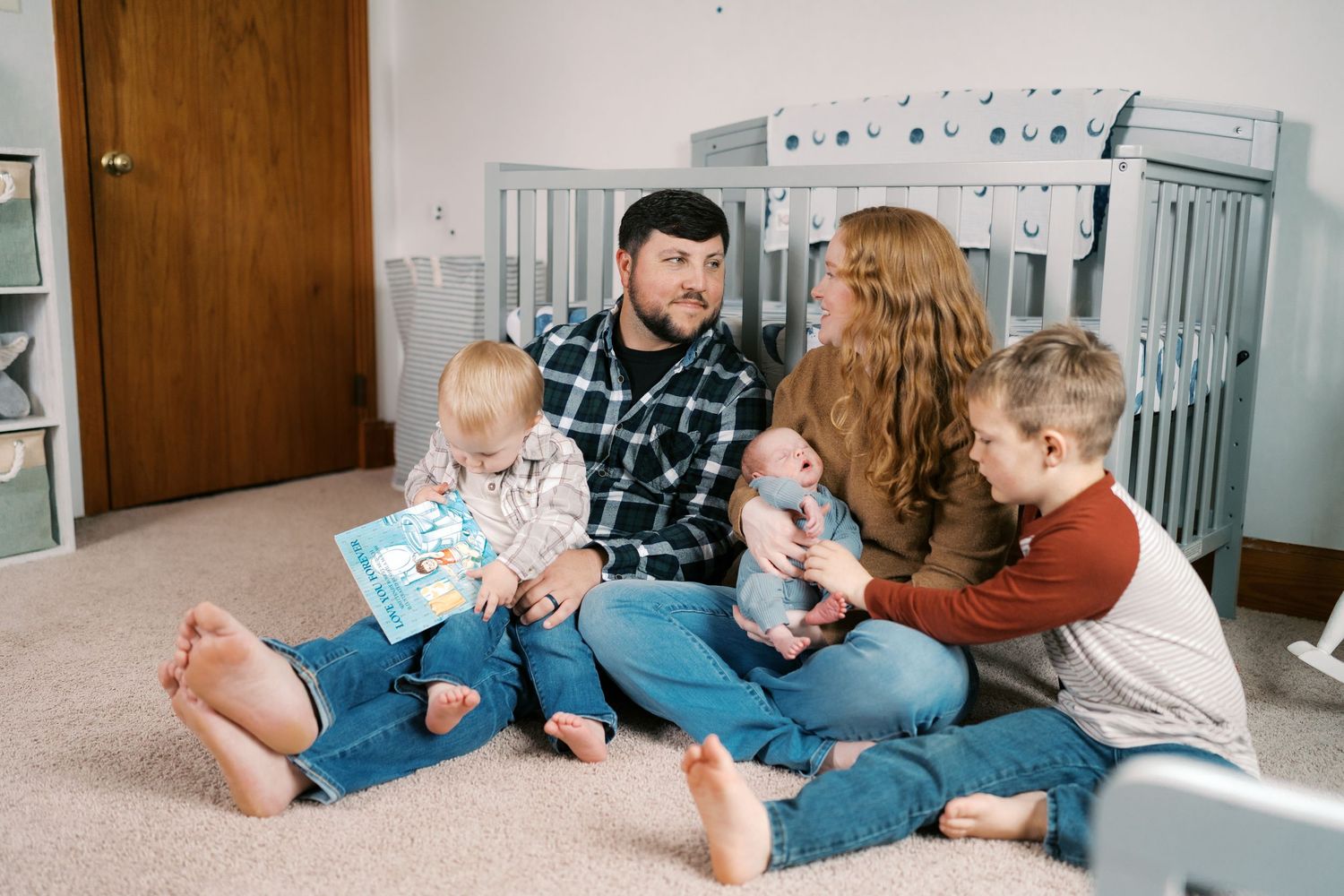 Family relaxing together on floor while reading books.