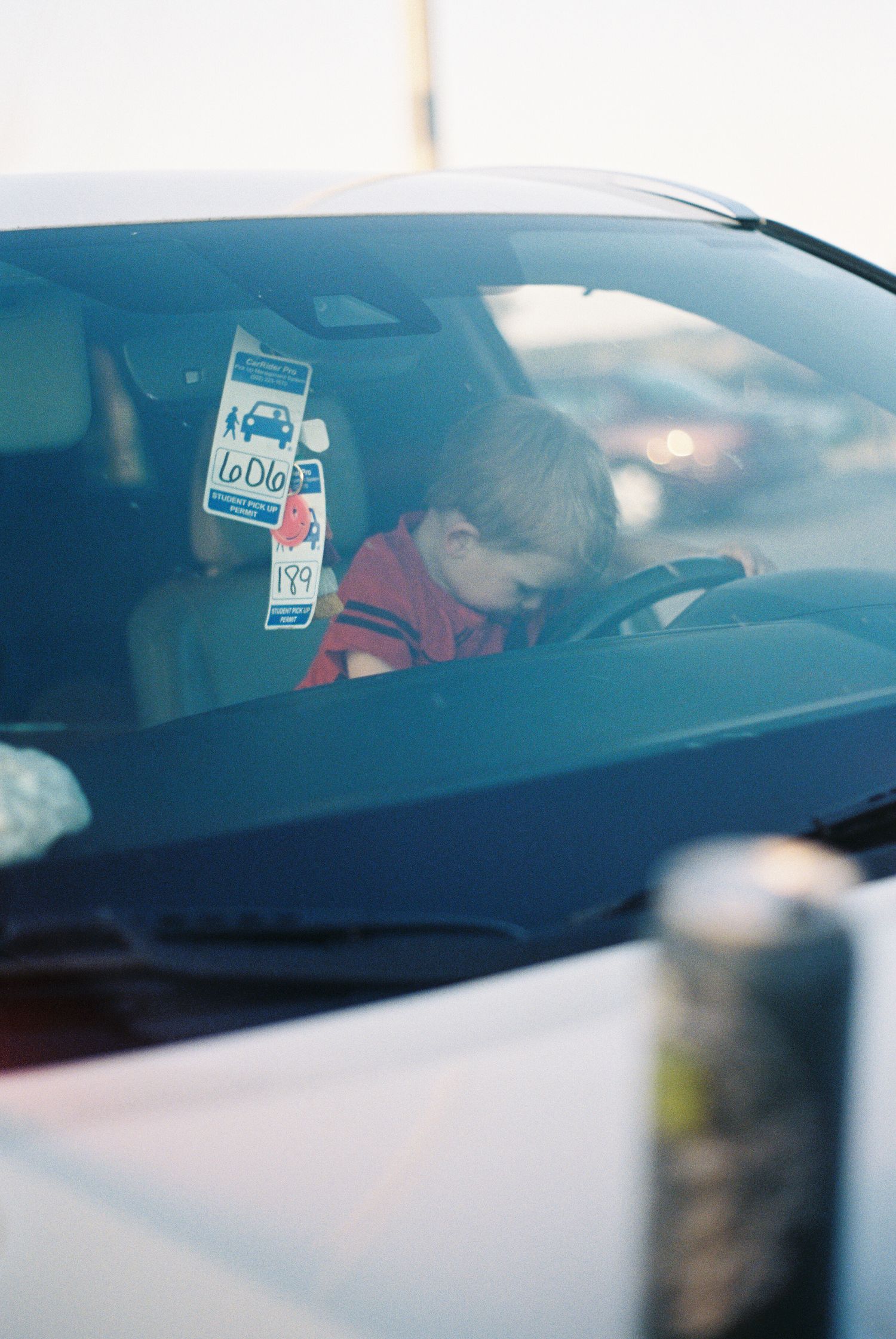 View through car windshield with stickers visible in soft focus.
