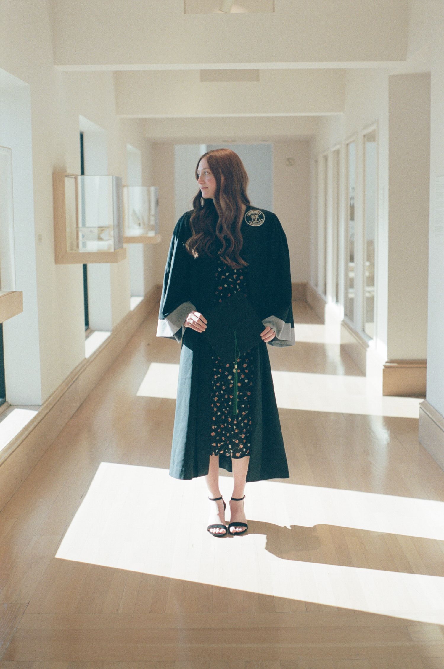 A series of artistic photos in a bright hallway showing a person in a black outfit against white walls and natural light.