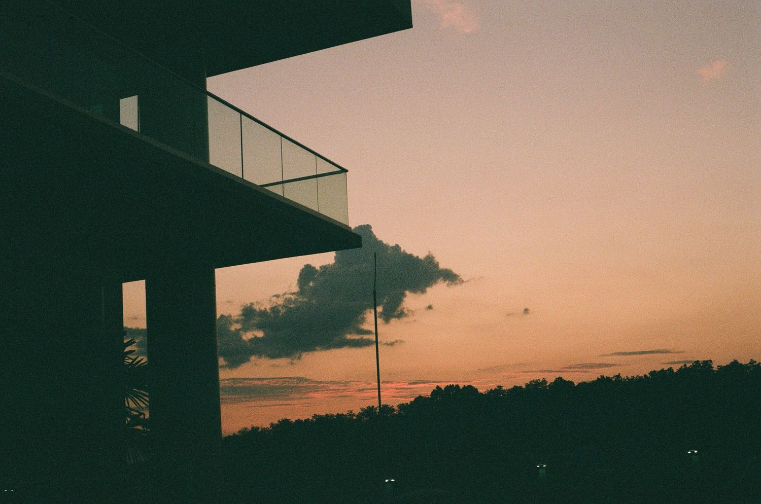 Urban skyline silhouetted against a warm gradient sunset.