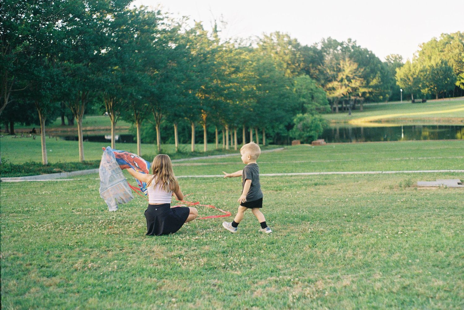 People relaxing on a grassy hill in a park during a sunny afternoon.