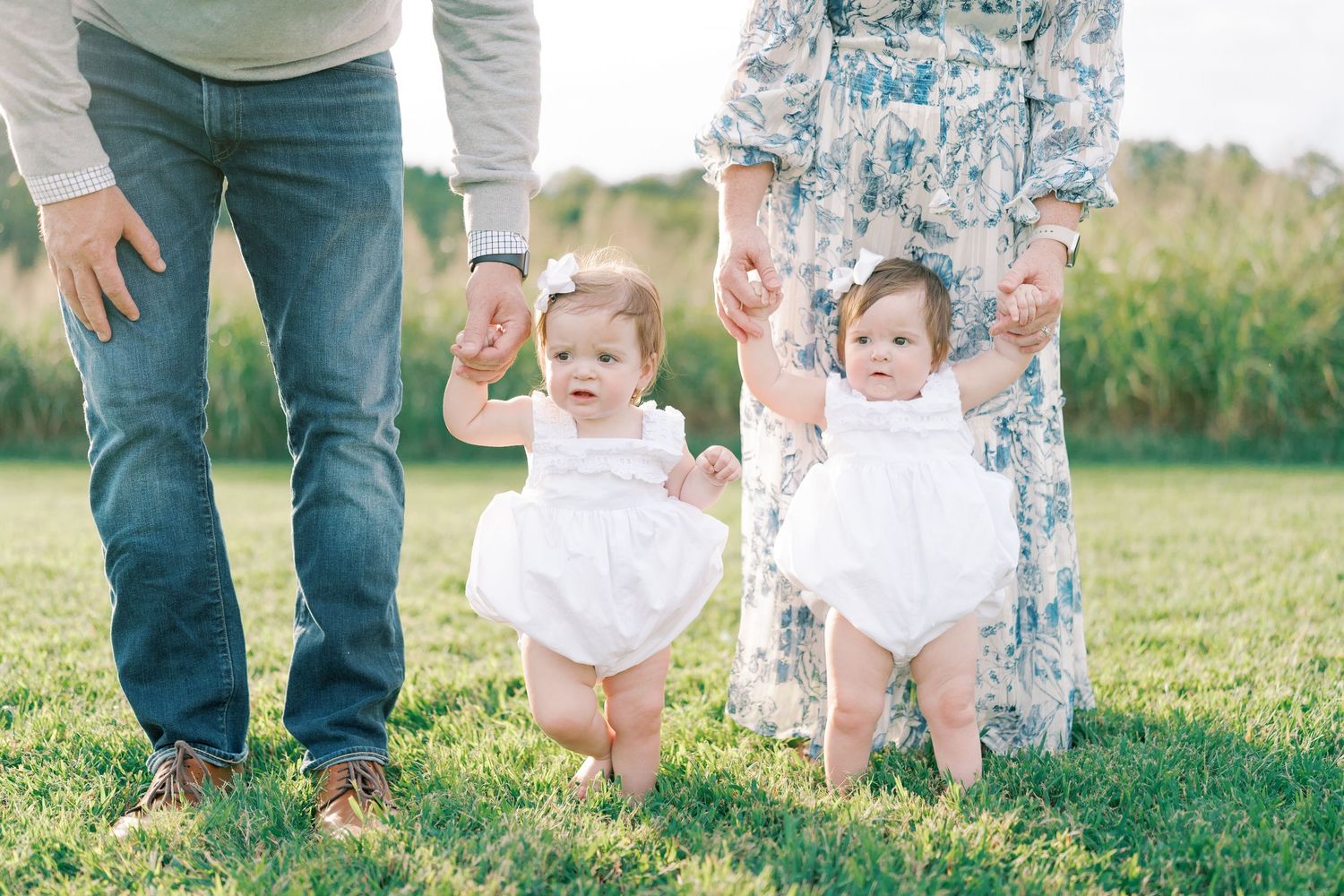 Casual family photo showing feet and legs on grass during outdoor portrait session.