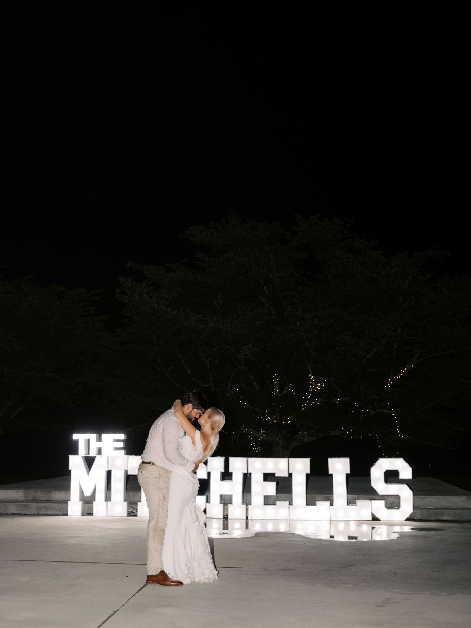 Illuminated white letter decorations spell out text against a dark nighttime background.