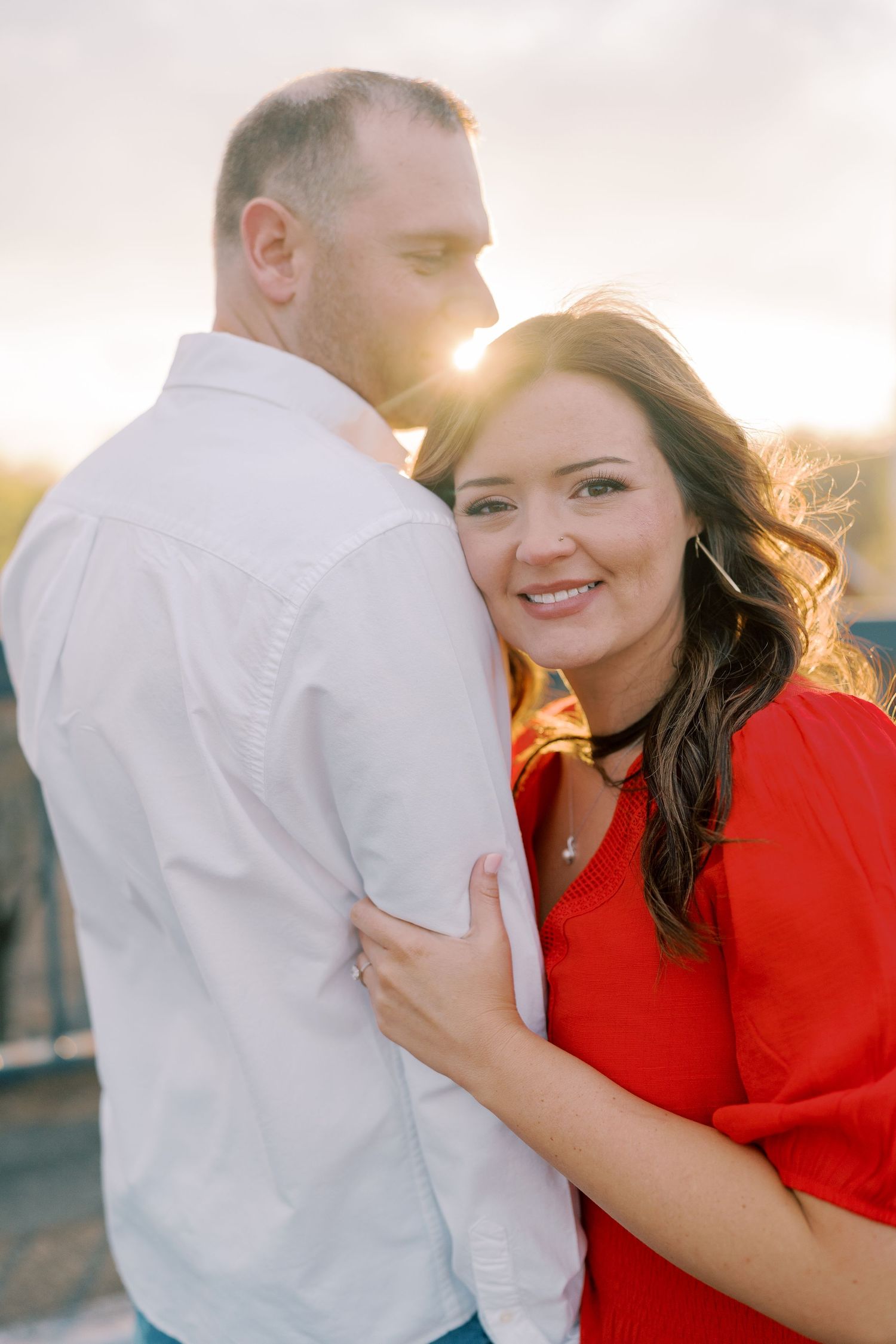 Couple shares romantic moment at sunset with warm golden lighting.