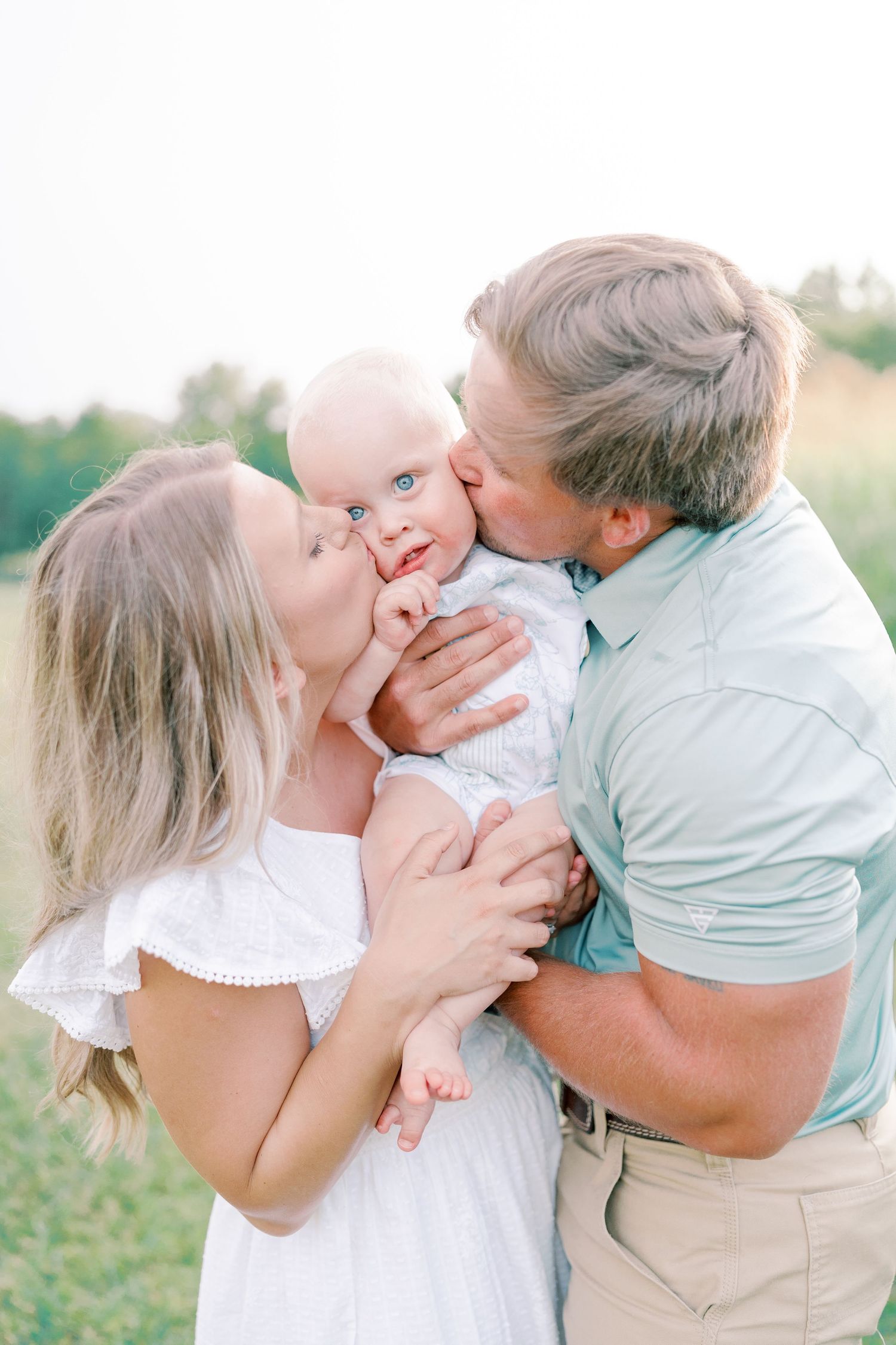 A tender family moment captured in a series of outdoor portraits showing affection and joy in a grassy field.