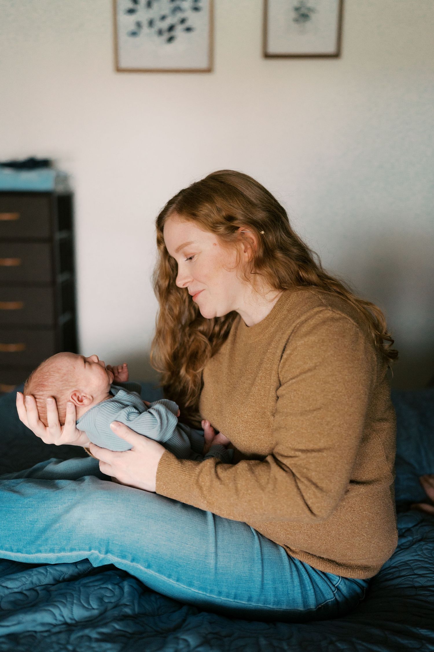 A series of intimate photos showing tender moments with a newborn baby on blue bedding.