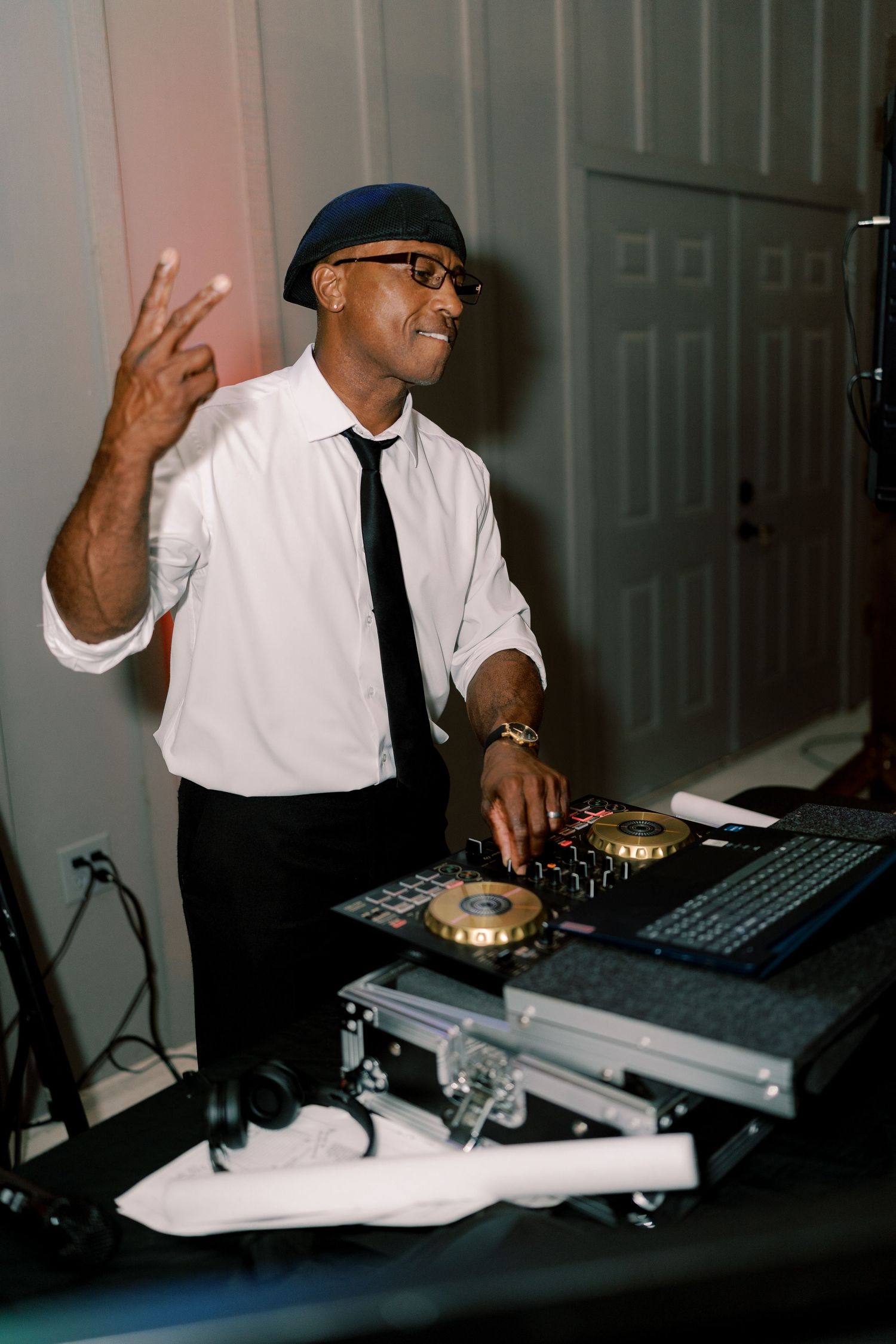 DJ performing at wedding reception with professional mixing equipment.