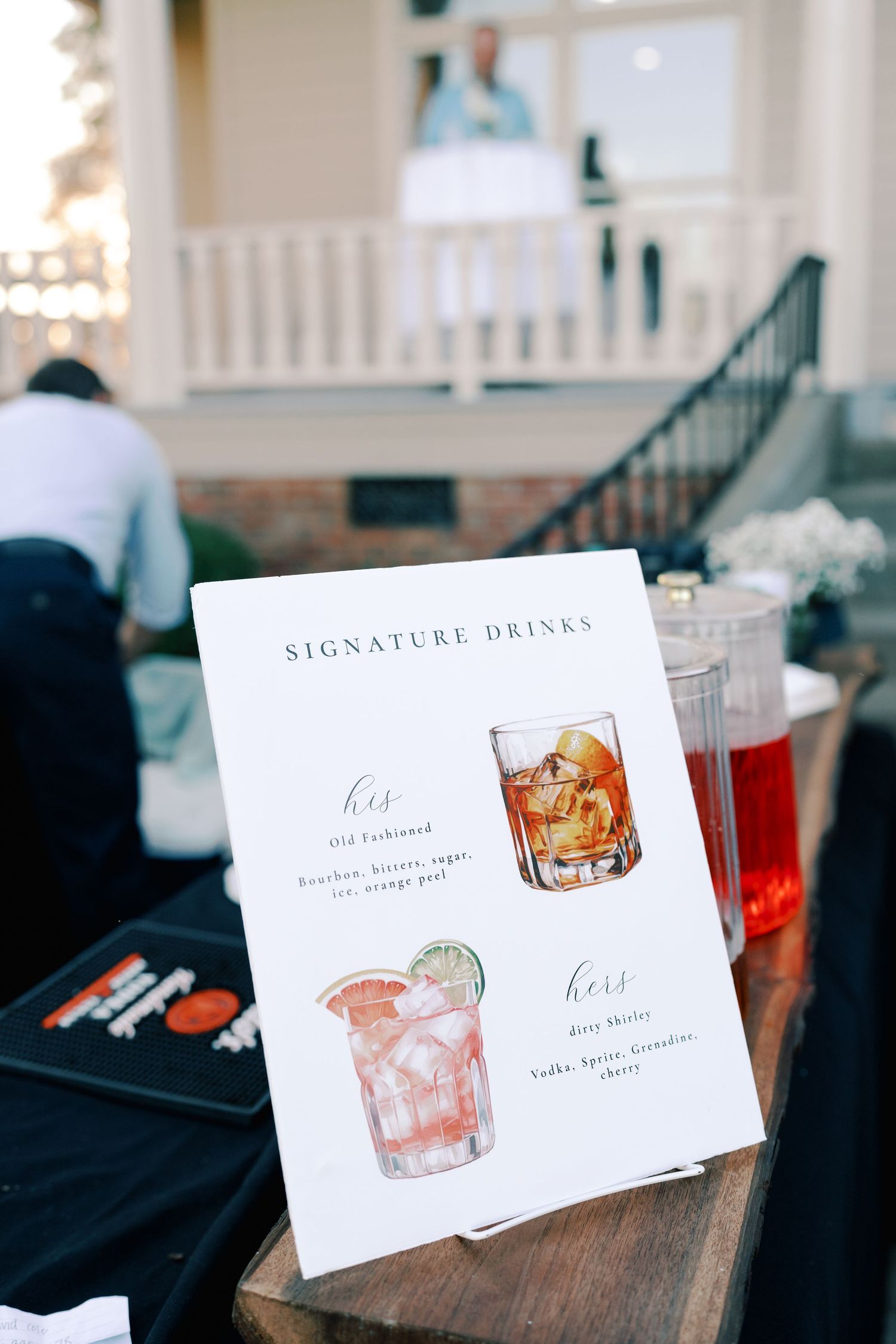 Signature drinks menu cards with illustrated cocktail designs at wedding reception.