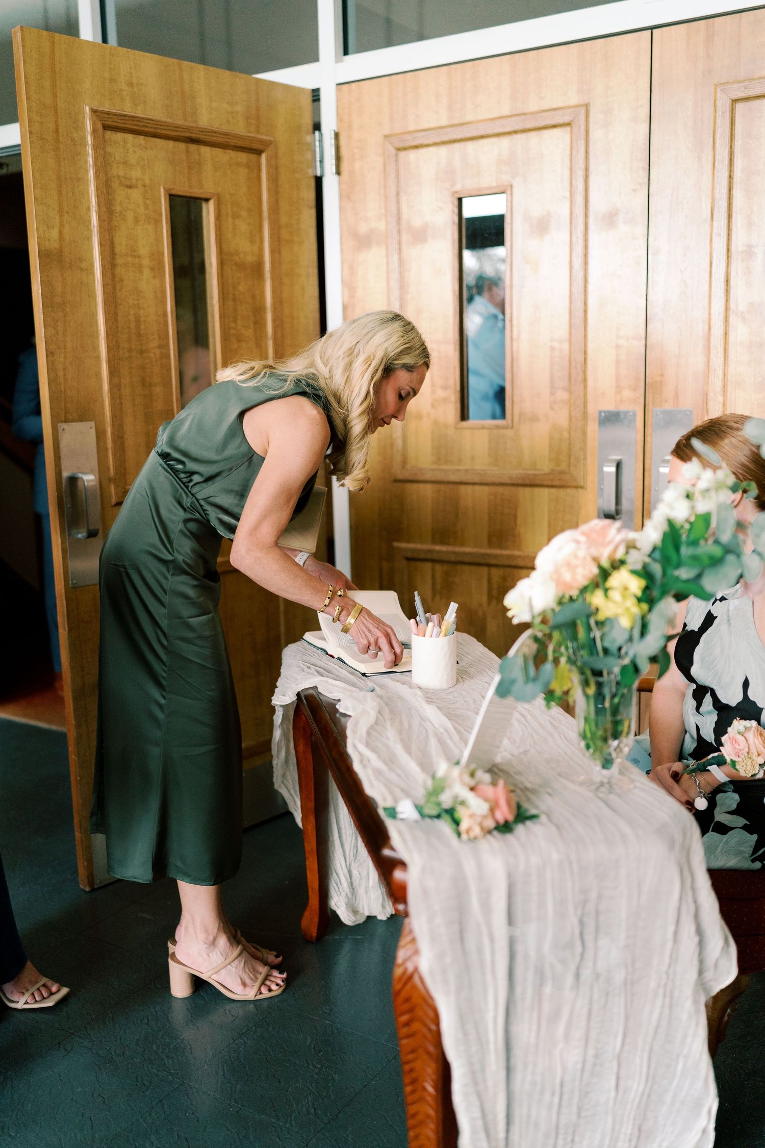 Someone adjusts a wedding dress on a table during pre-ceremony preparations.