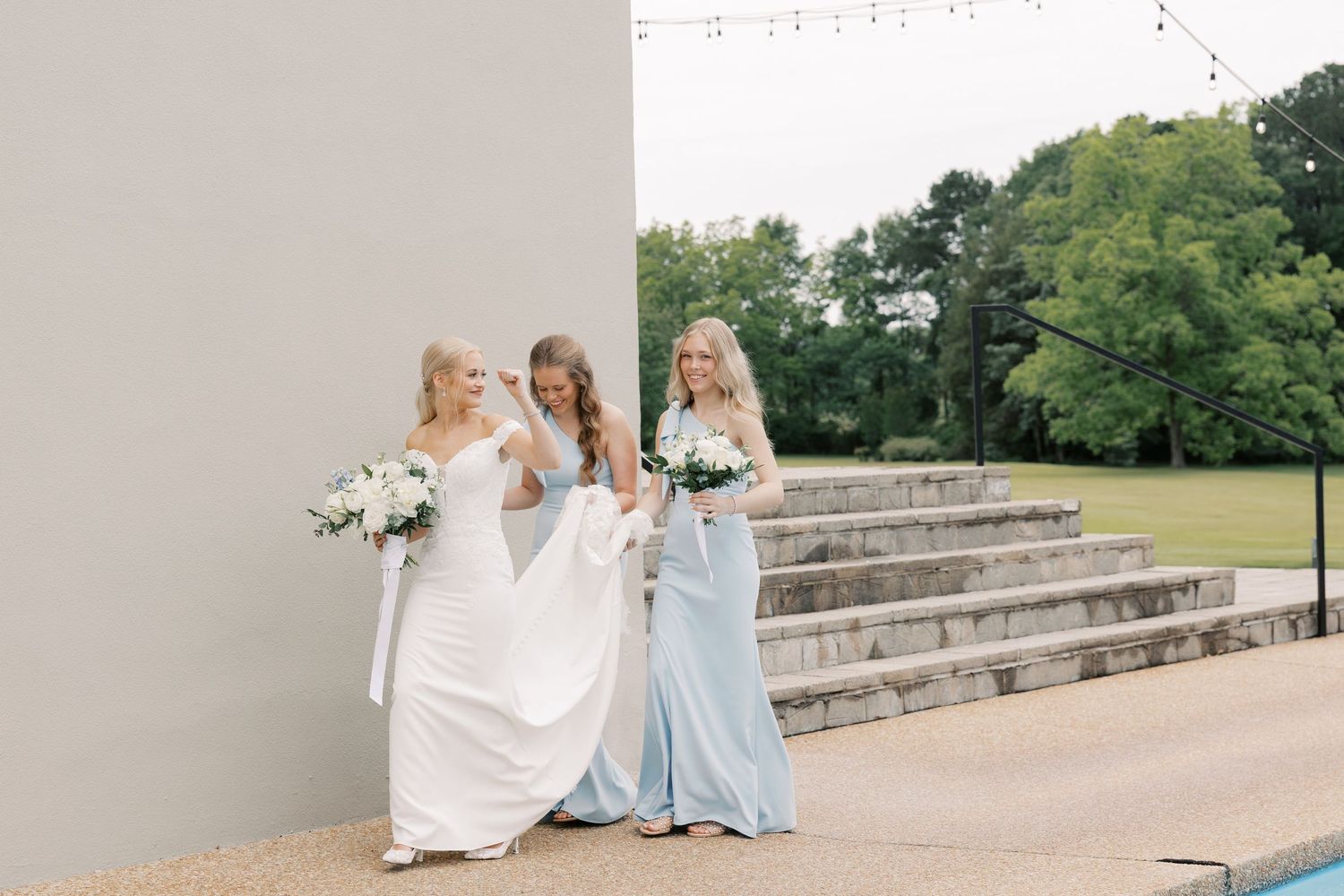 Modern wedding venue exterior with stone steps and string lights creates an elegant backdrop.