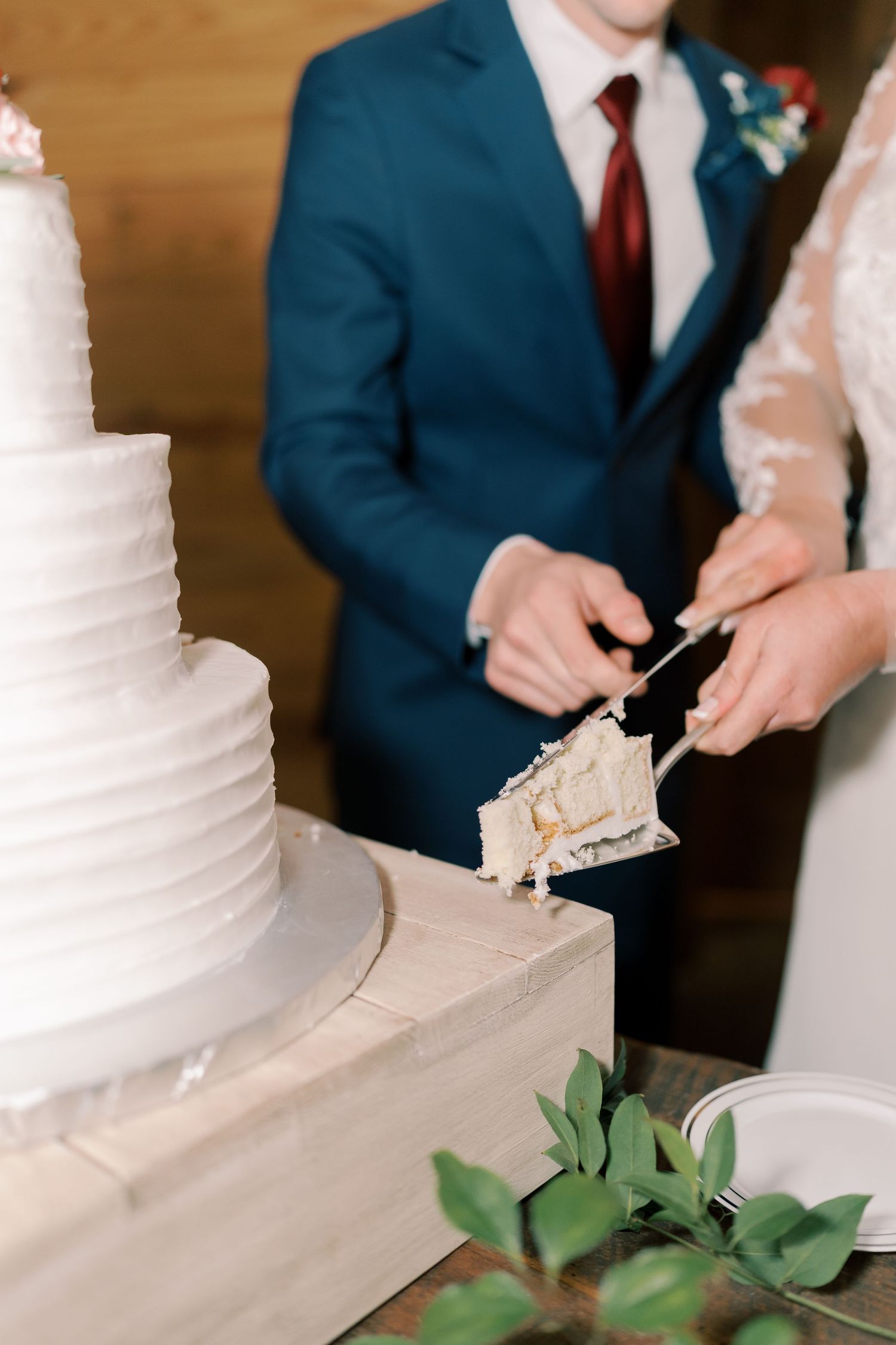 Couple cutting their elegant white wedding cake together during the reception.