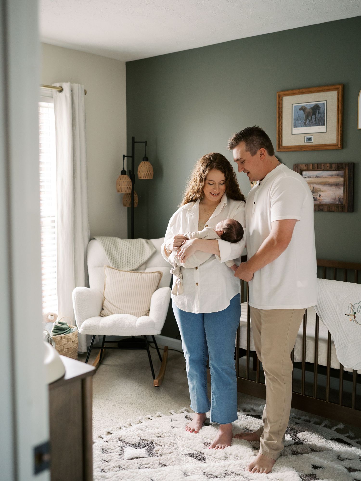 Couple sharing sweet moments in a room with sage green walls and natural lighting.