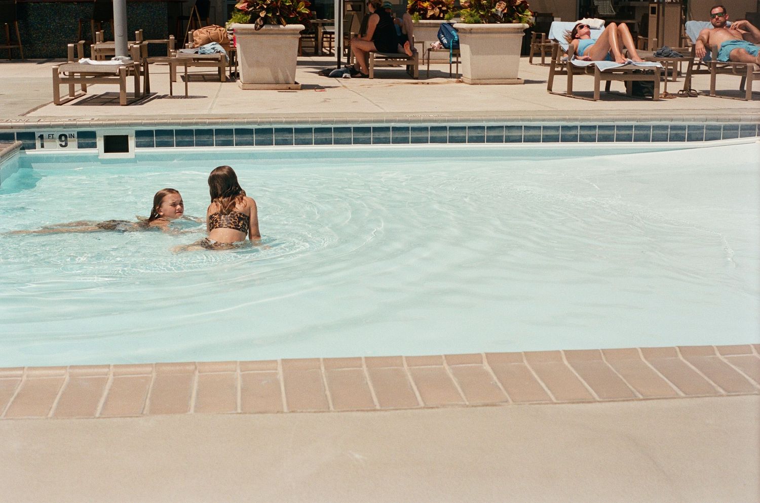 Swimmers enjoying a refreshing day at an outdoor swimming pool.