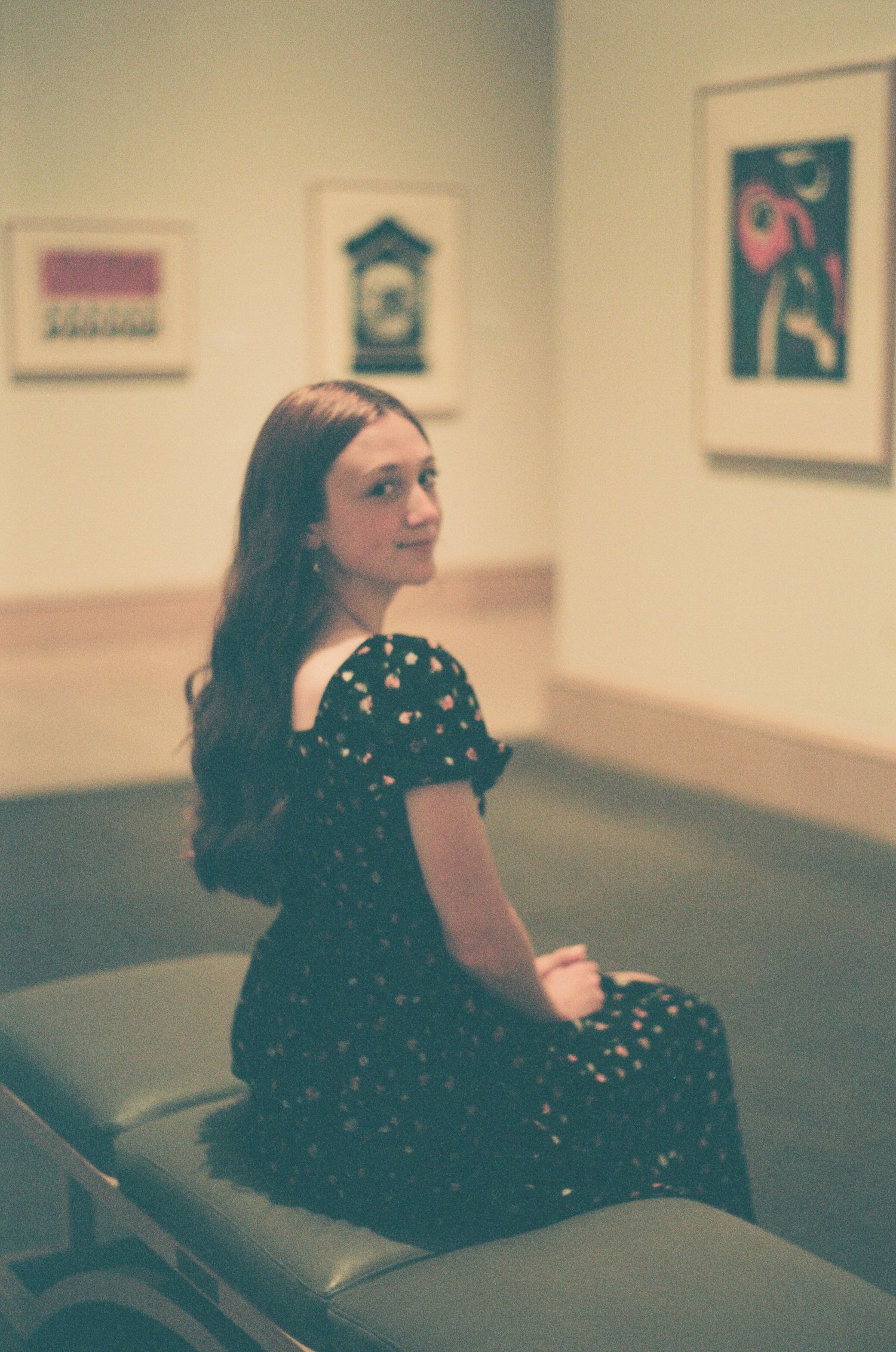 Vintage-style photos of someone in a polka dot dress lounging in an art gallery space.
