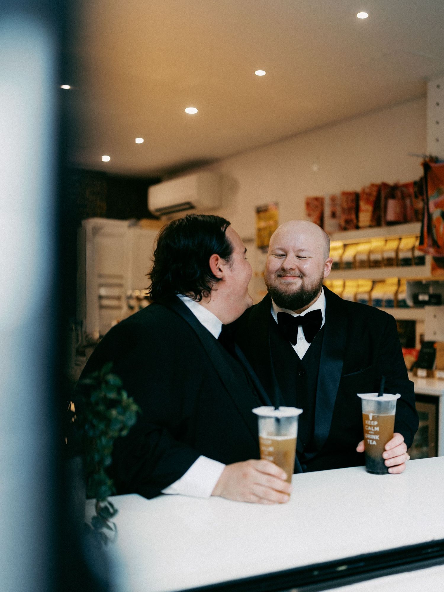People in formal attire sitting at a counter in a modern establishment.