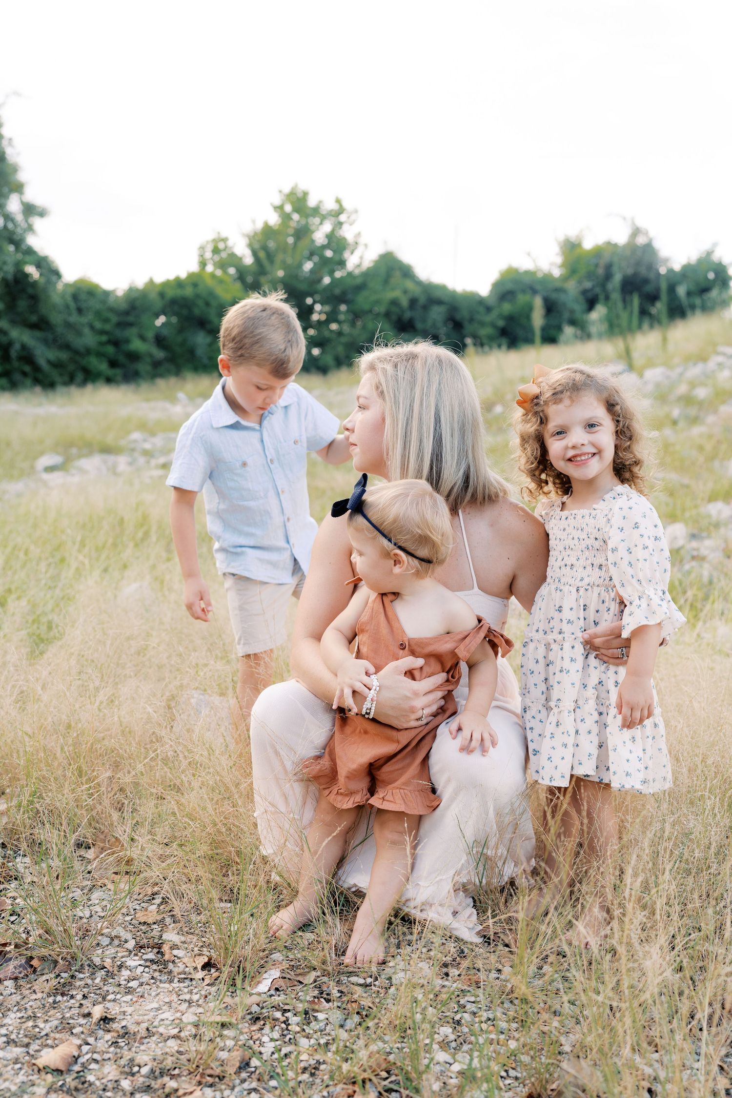 Heartwarming family portrait in a natural setting with tall grass and greenery.