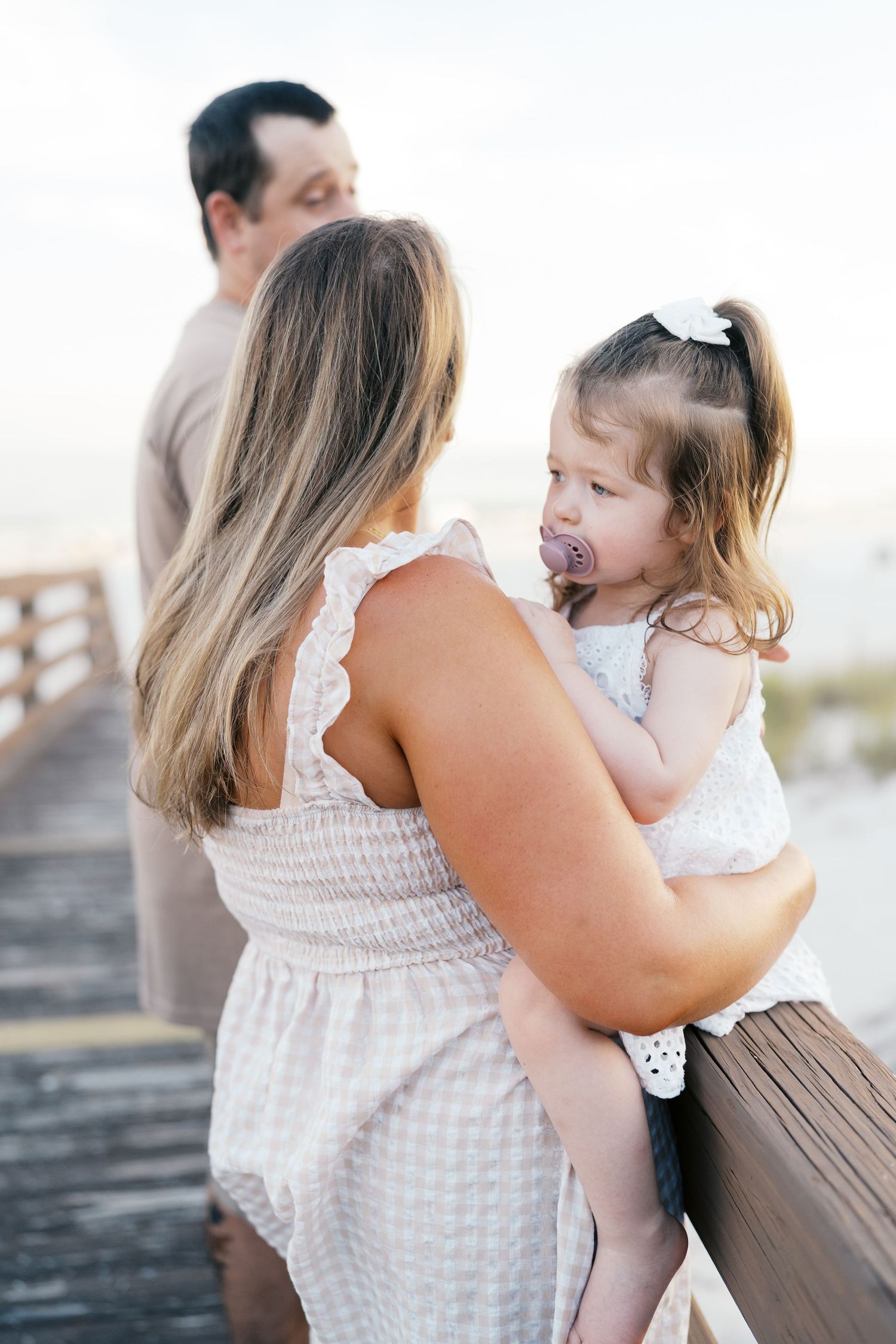 A parent and child share tender moments together on a sunny day outdoors.