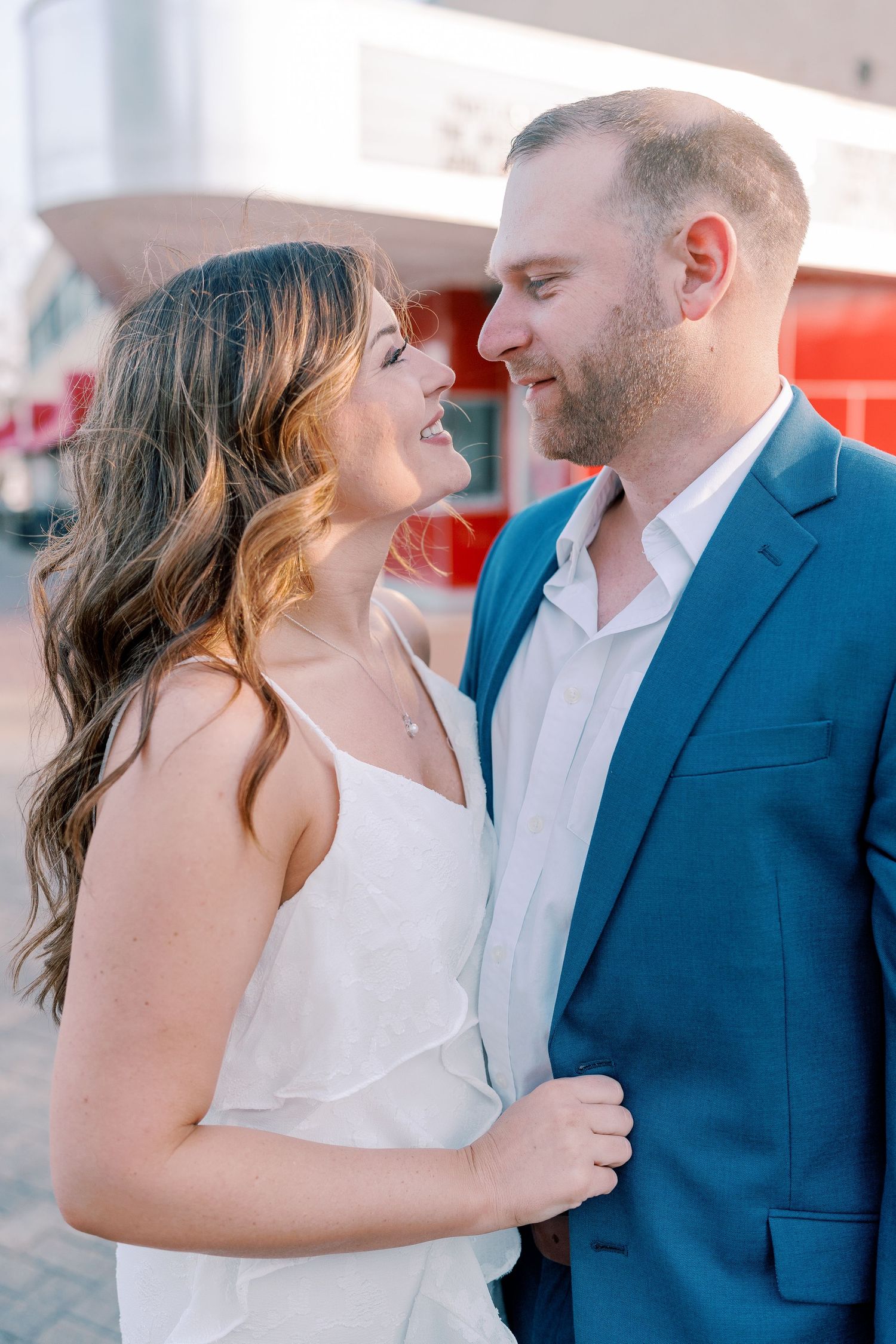 Tender moment between couple against light background during portrait session.