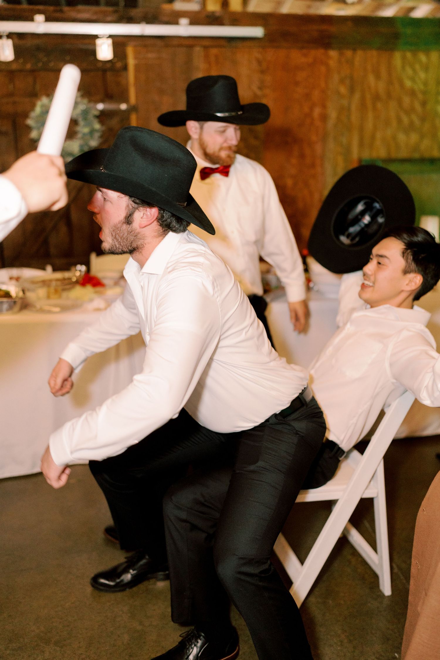 Dancers in formal attire performing coordinated dance moves at a western-themed event.