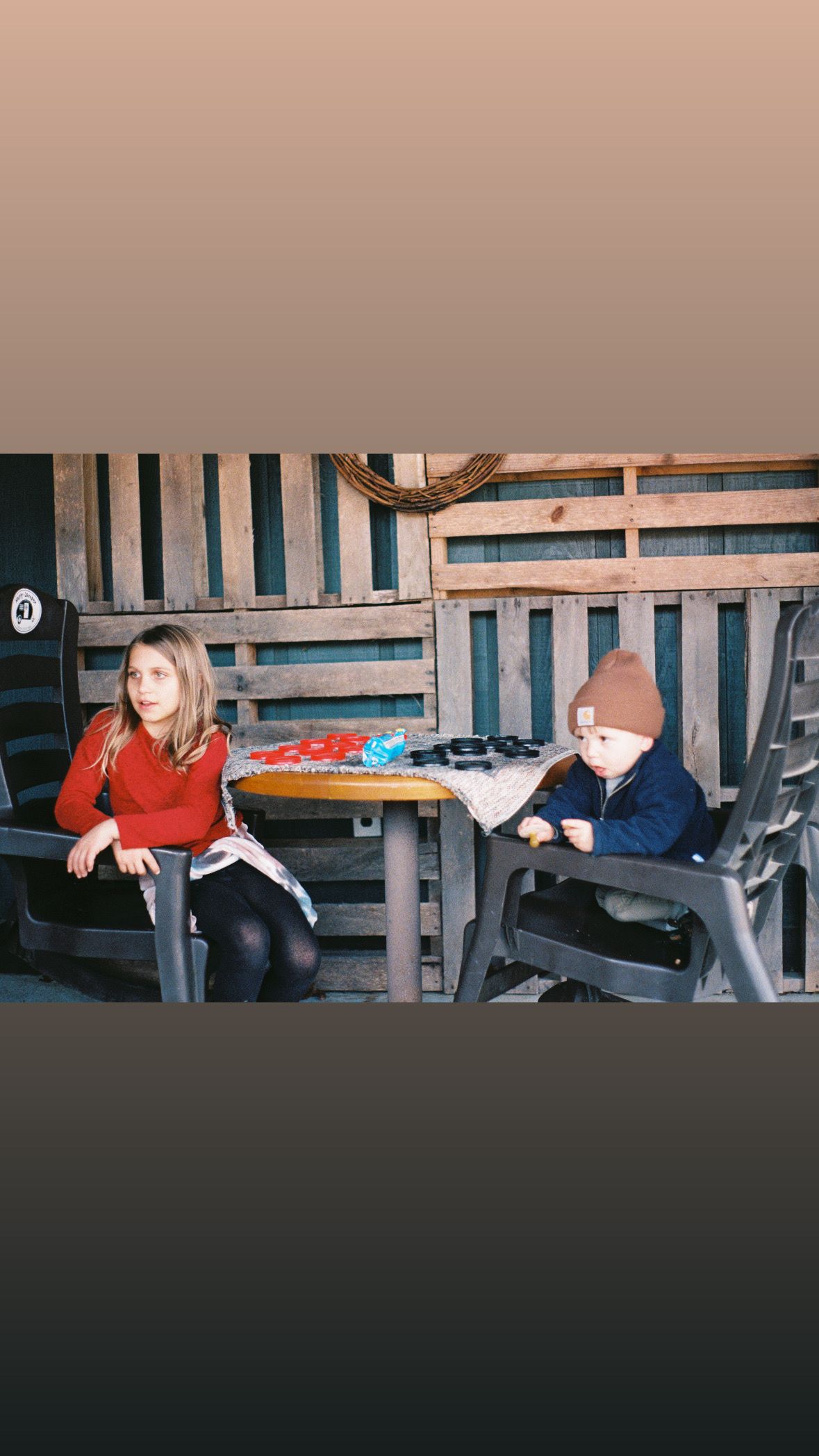 People relaxing in wooden benches at an outdoor gathering space.