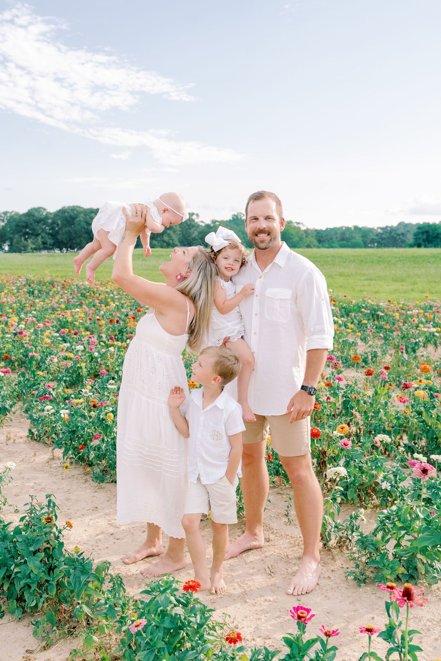 Family shares joyful moments together in field of colorful summer flowers.