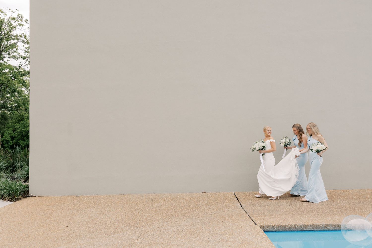Contemporary wedding venue exterior with pool and landscaping visible in background.