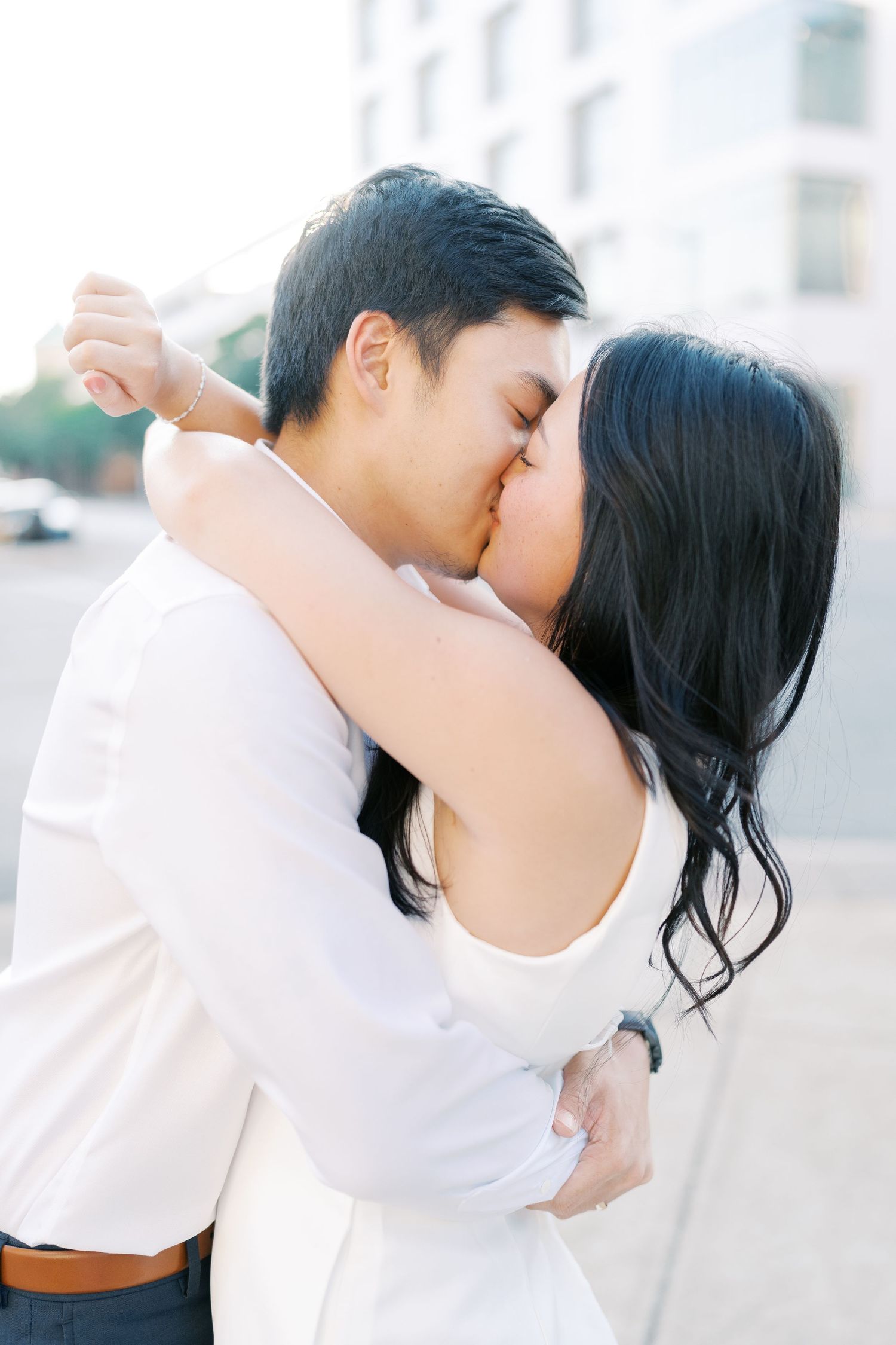 A romantic couple shares an intimate moment during an urban photoshoot.