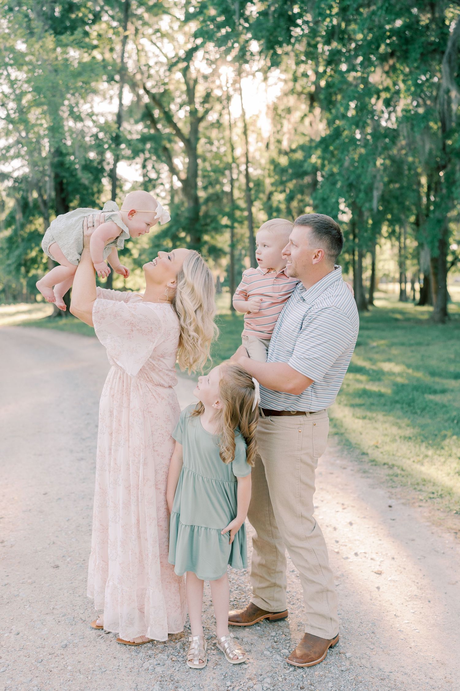 Family shares joyful moments together during outdoor photo session in park.