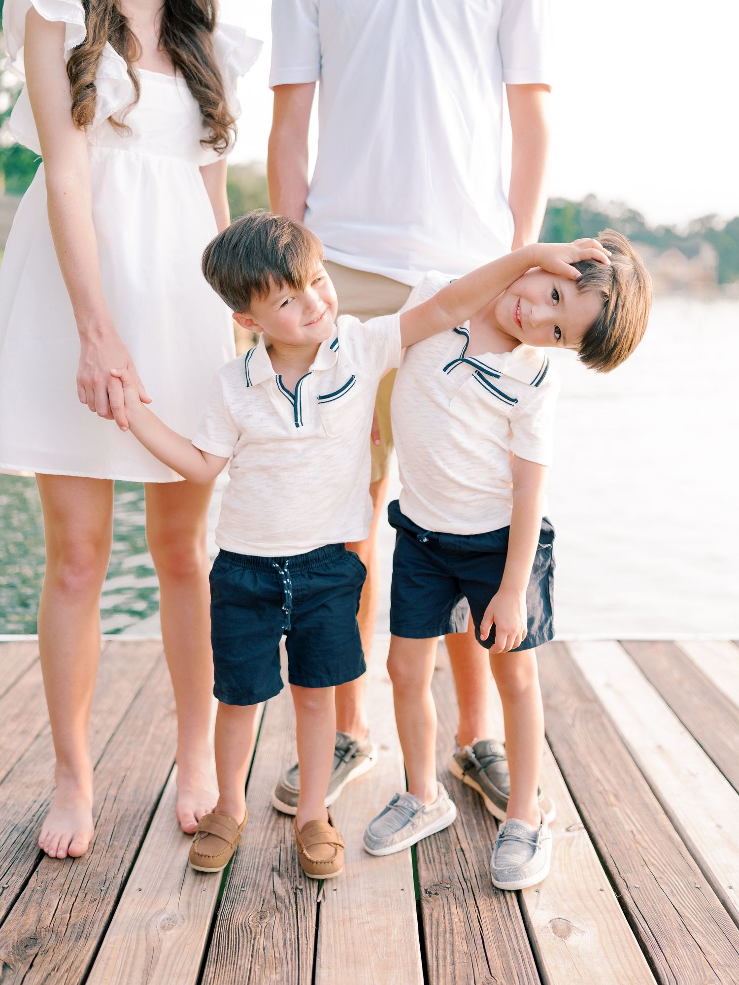 Row of family members' feet and legs on wooden dock wearing coordinated summer attire.