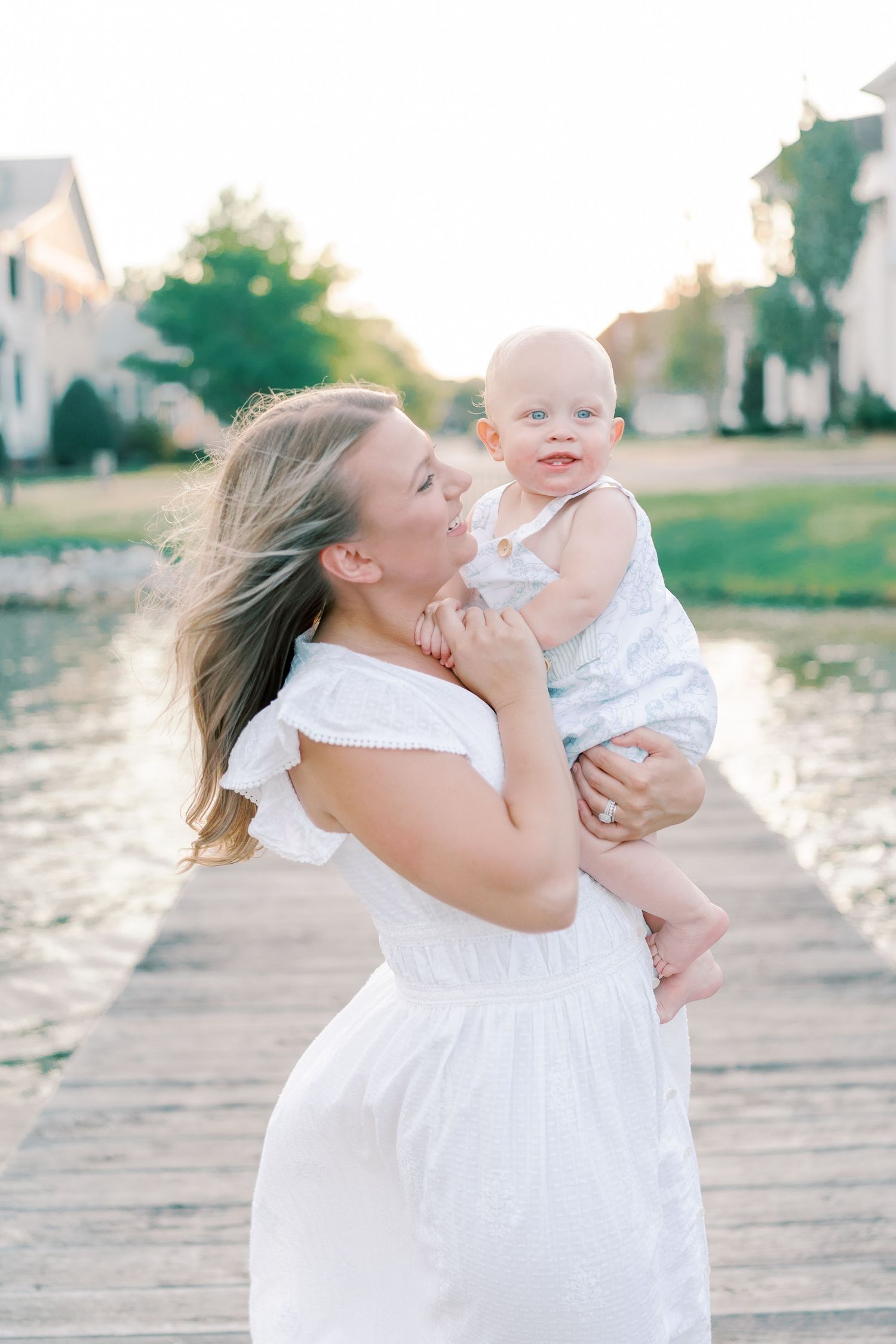 Candid family photos showing joyful interactions on a wooden pier by the water.